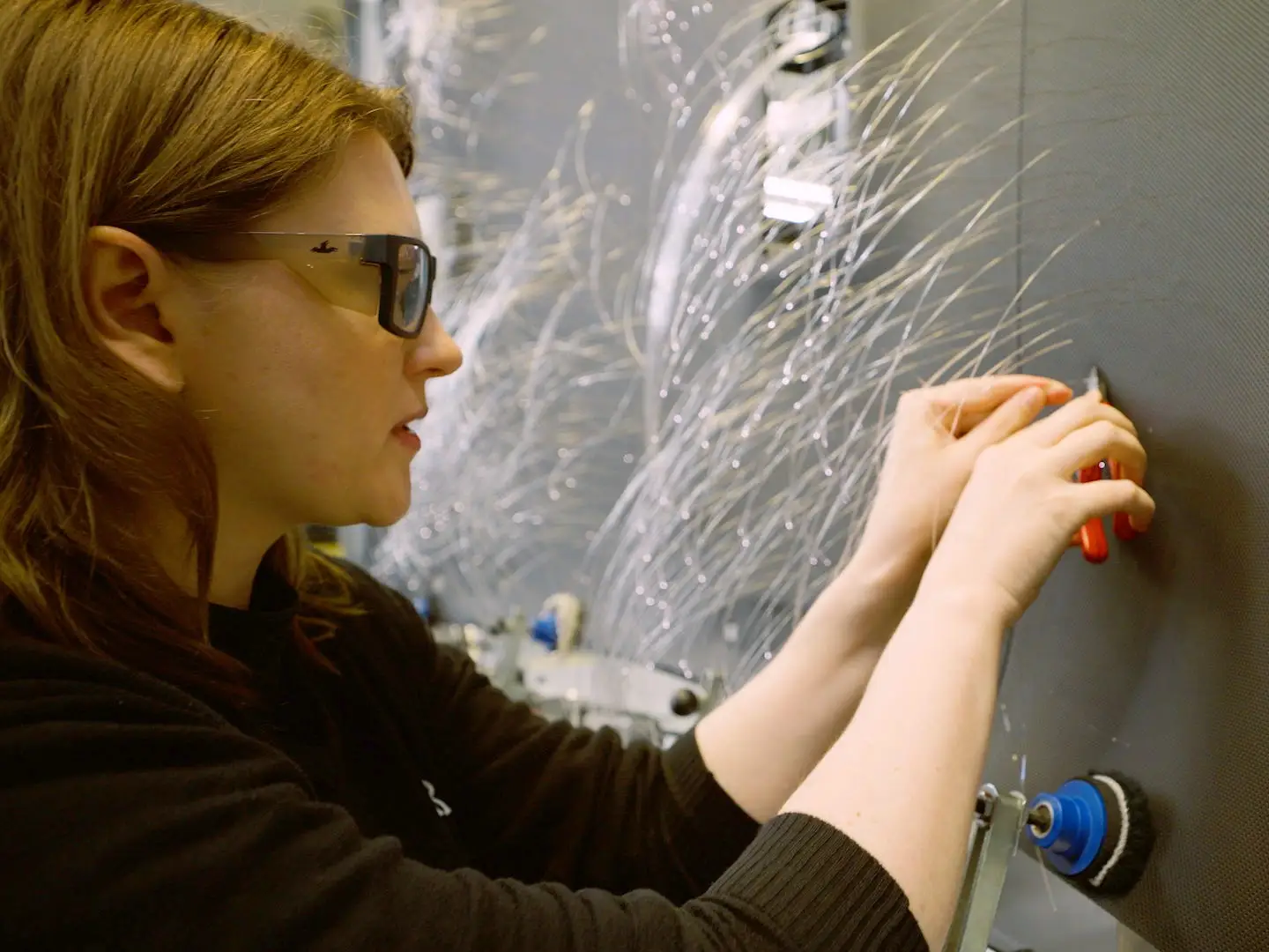 A worker clips the fiber-optic strands to create the starry-sky ceiling facade.