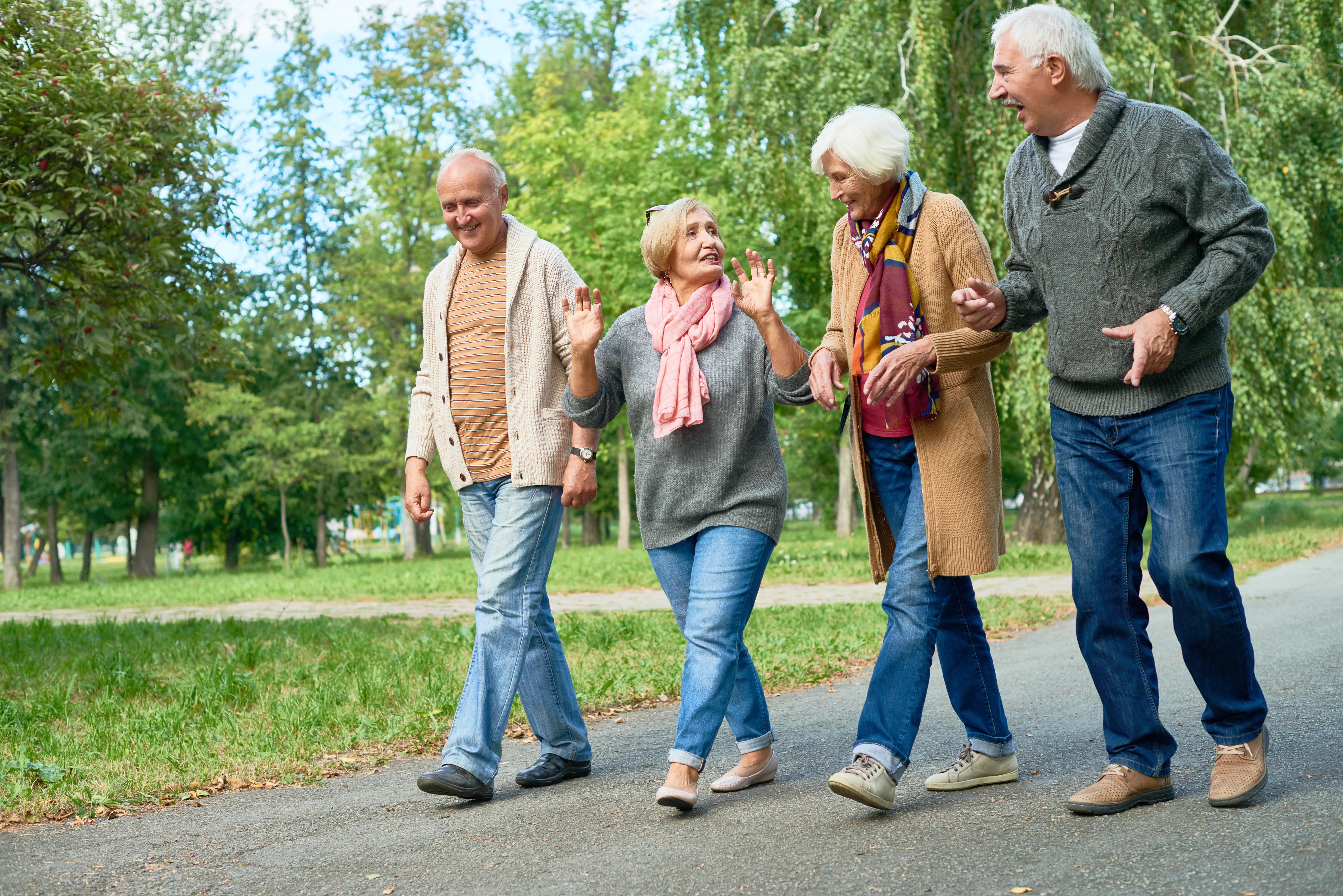 two elderly couples walking outside