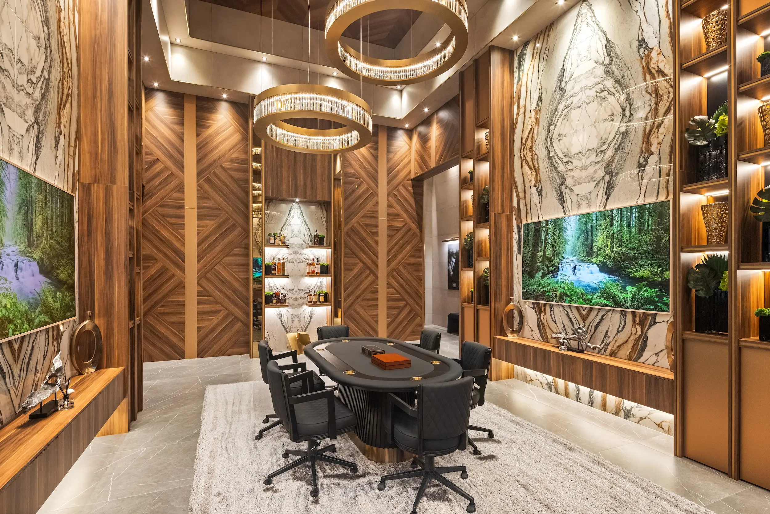 Luxurious wood-and-marble poker room with ring chandeliers, a large table, black chairs, shelves, and wall-mounted screens.