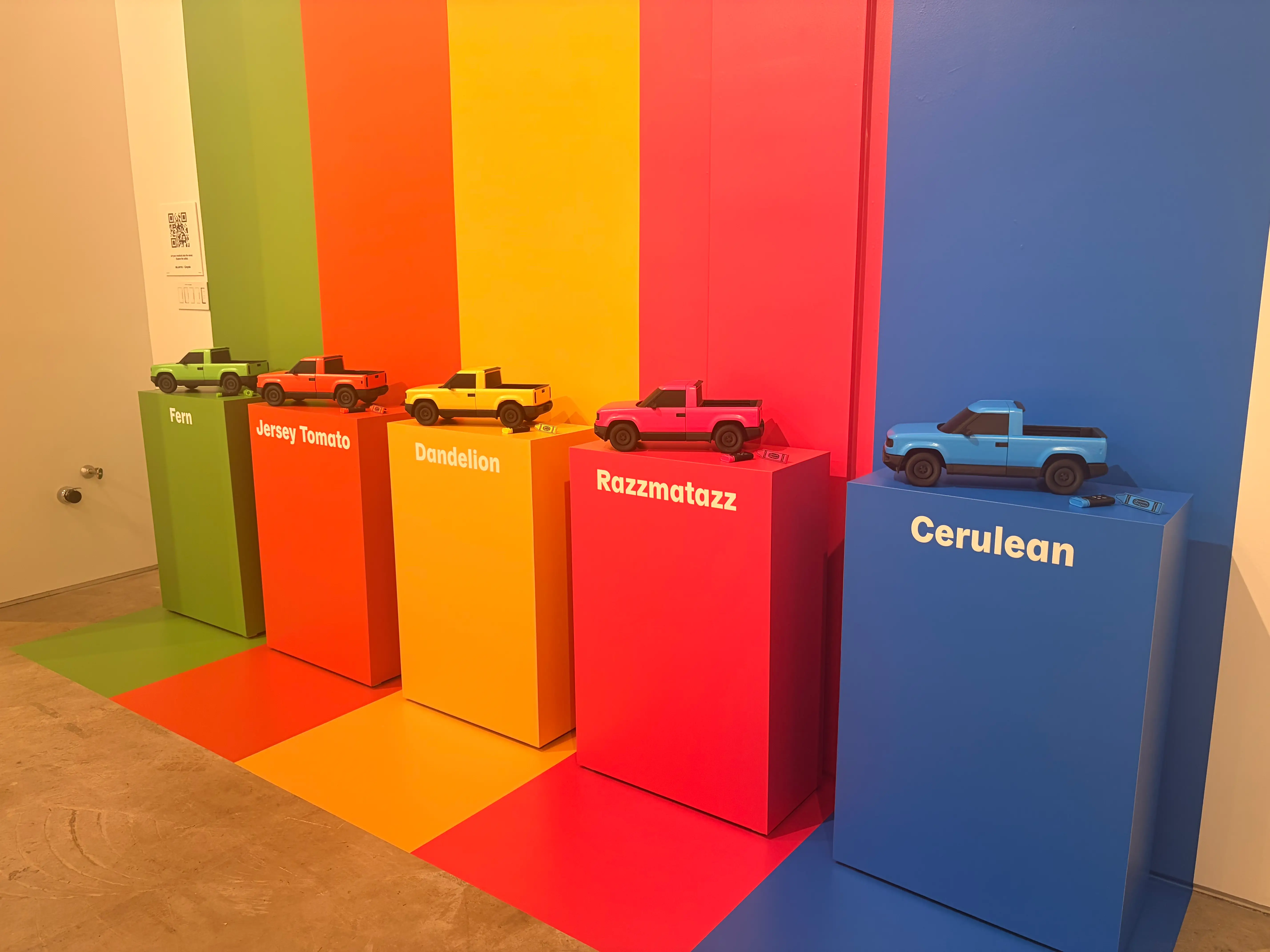 Five stands with tiny Slate models are lined next to a wall. They show the five colors available in the Crayola partnership: fern, jersey tomato, dandelion, razzmatazz, and cerulean.
