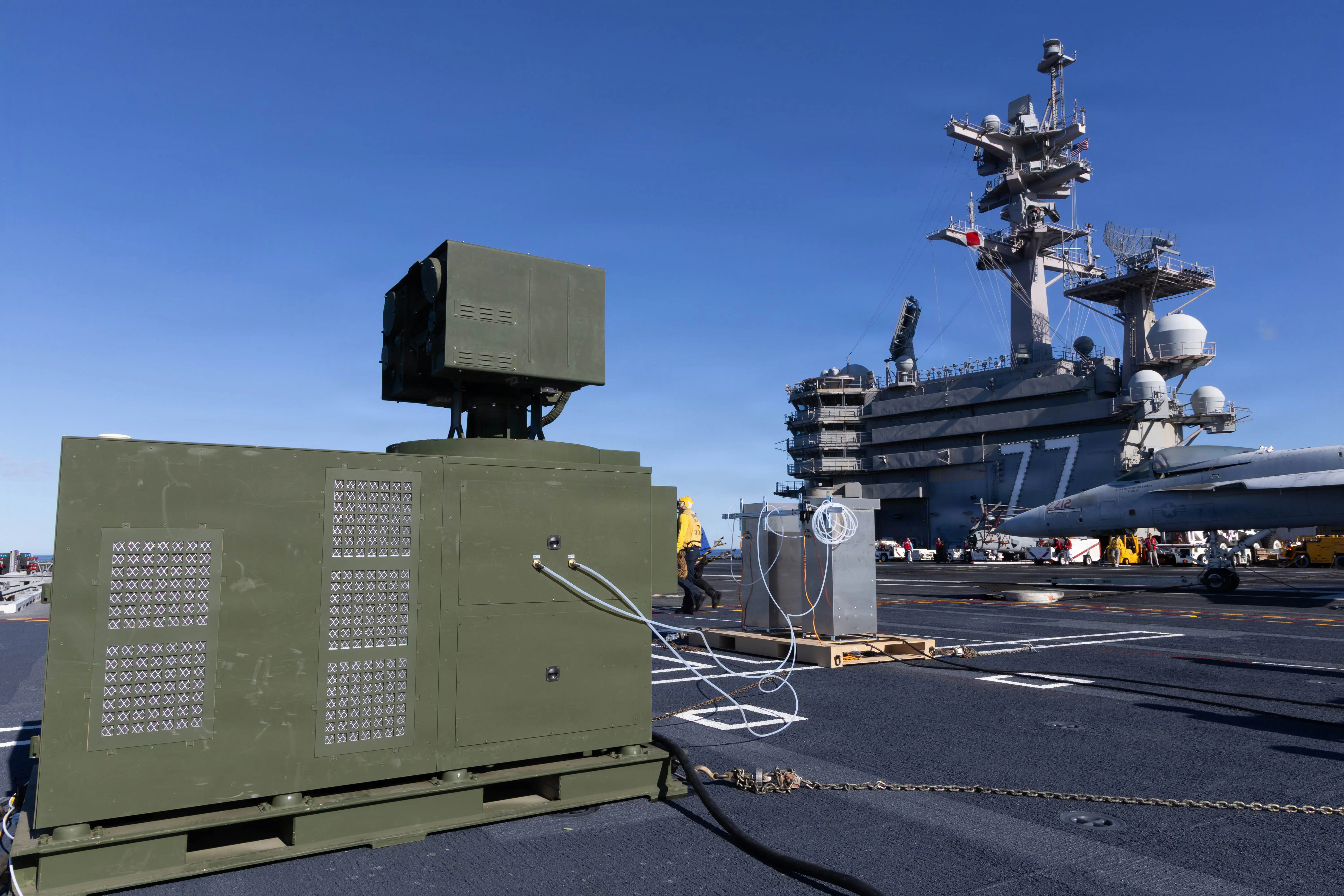 A large green container is seen aboard a US aircraft carrier.