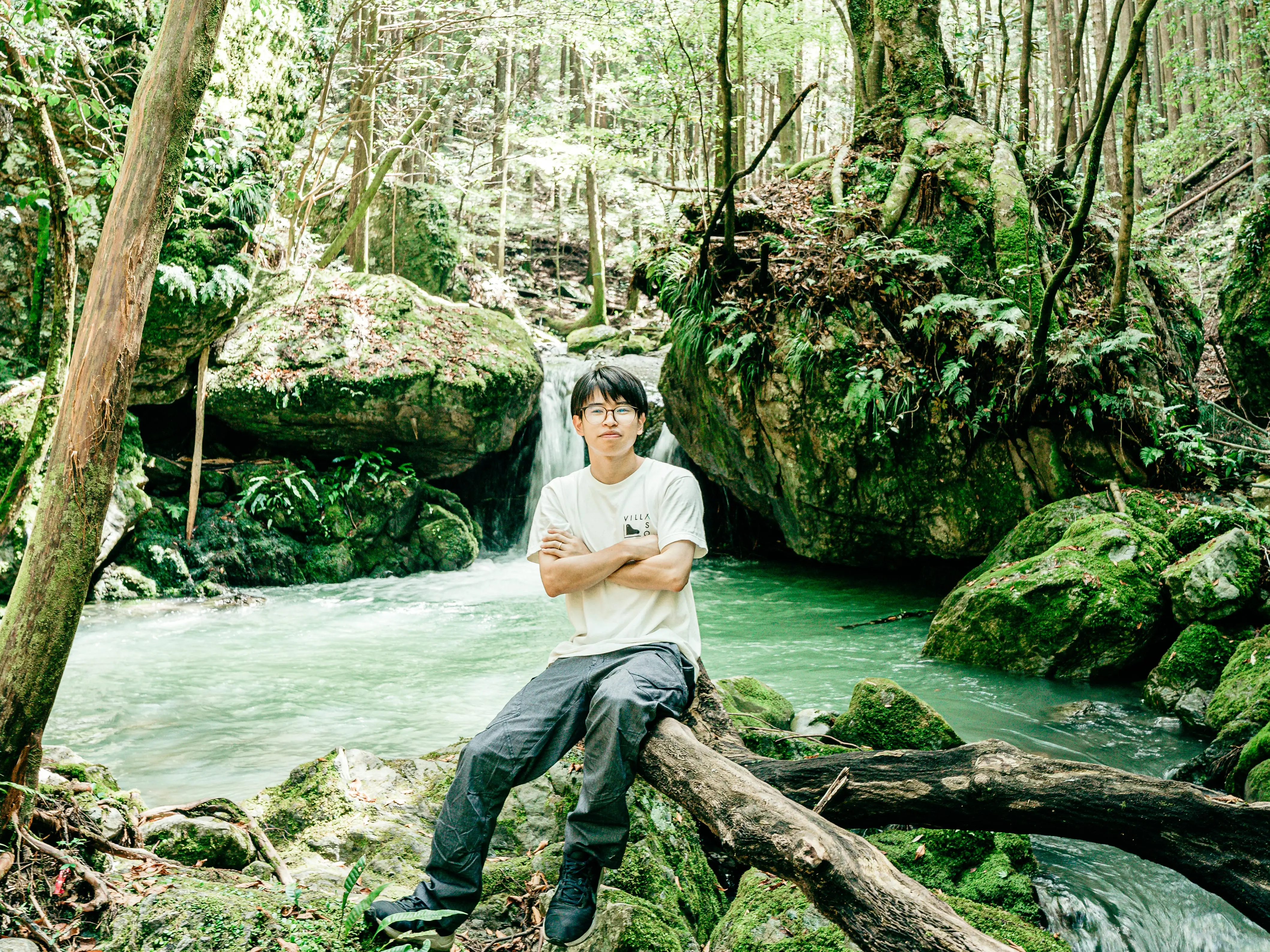 A man sitting by a waterfall in Japan.