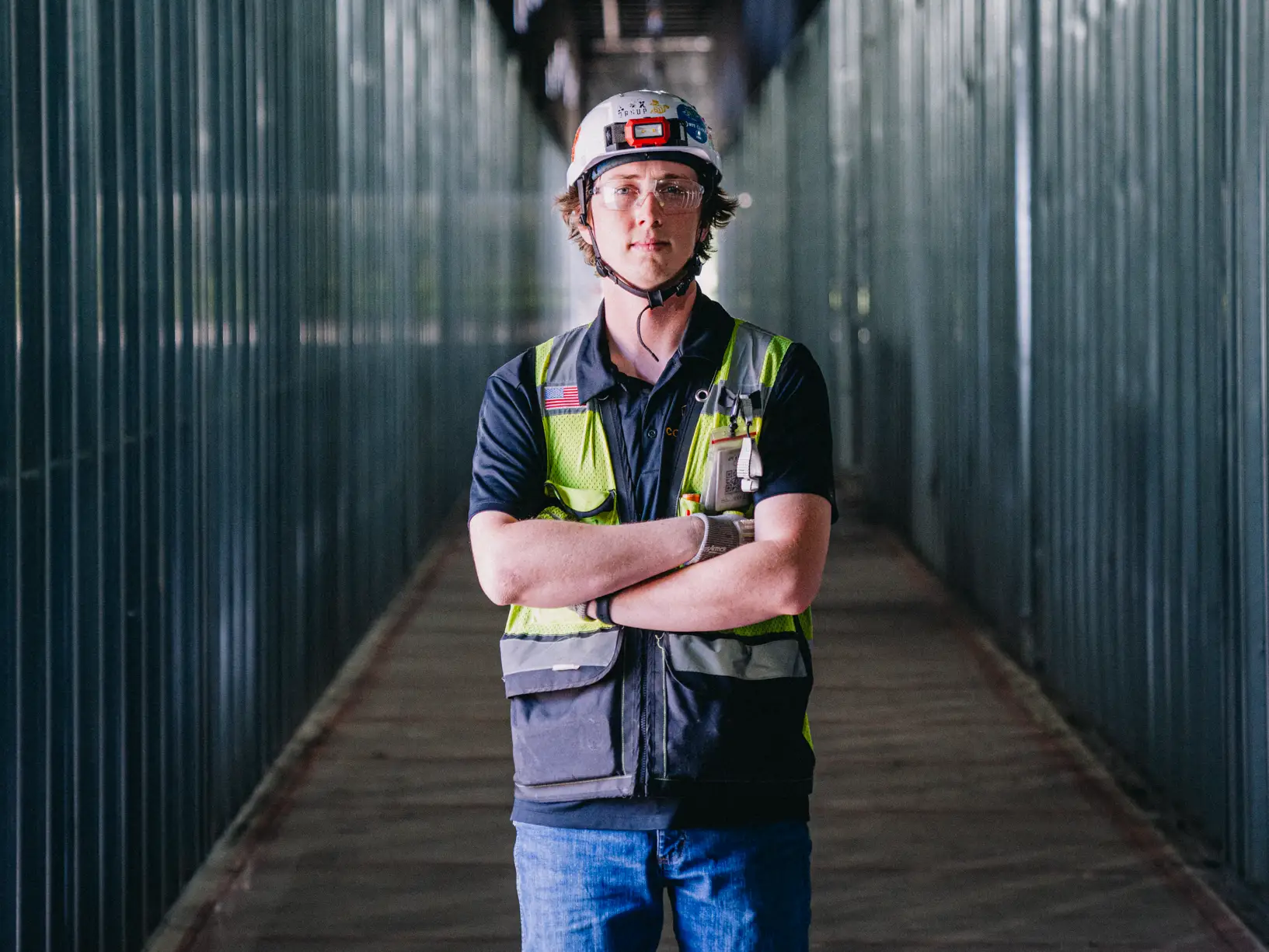 Cody Cole wears a hard hat and yellow work vest
