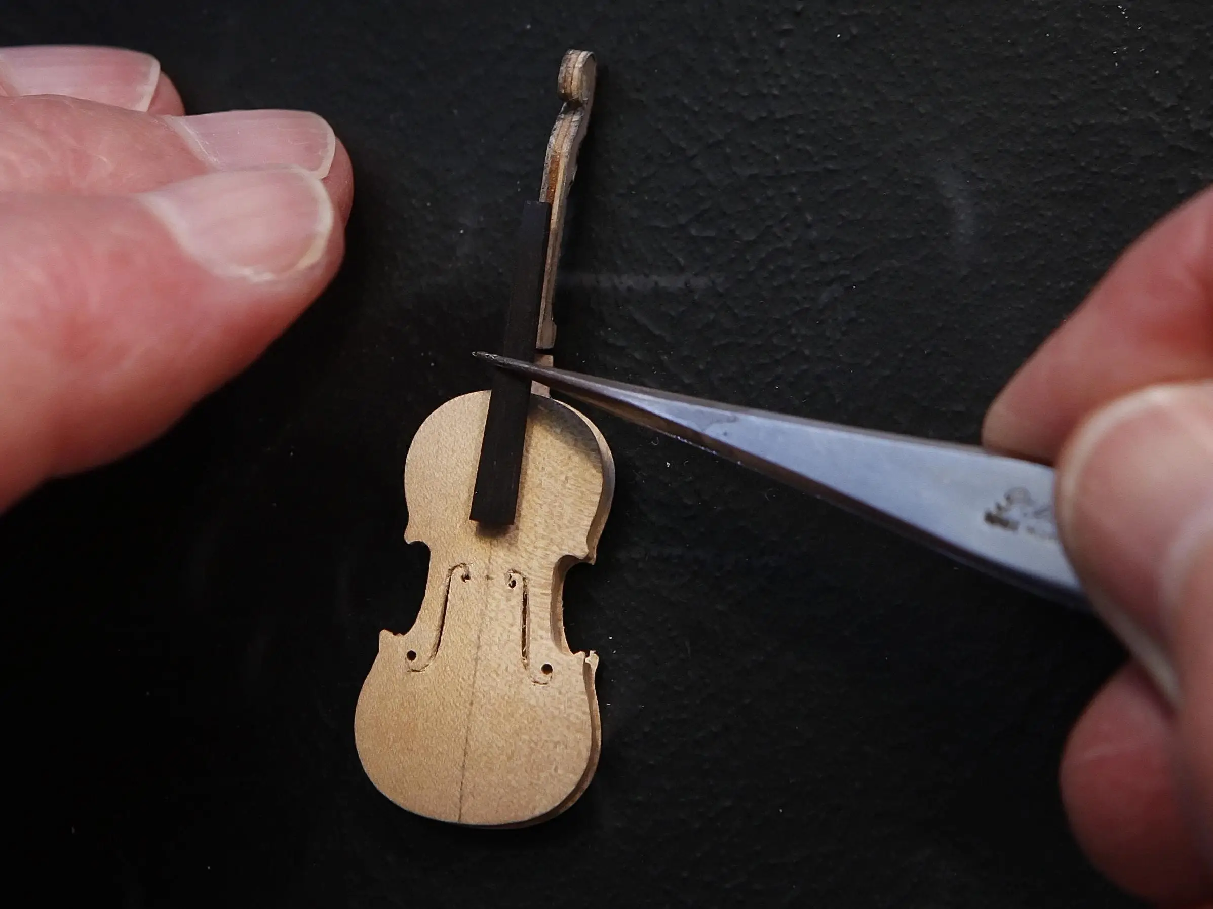 Former Royal Philharmonic Orchestra cellist David Edwards crafts a miniature Stradivarius violin, complete with sheep gut strings, in his Edinburgh workshop