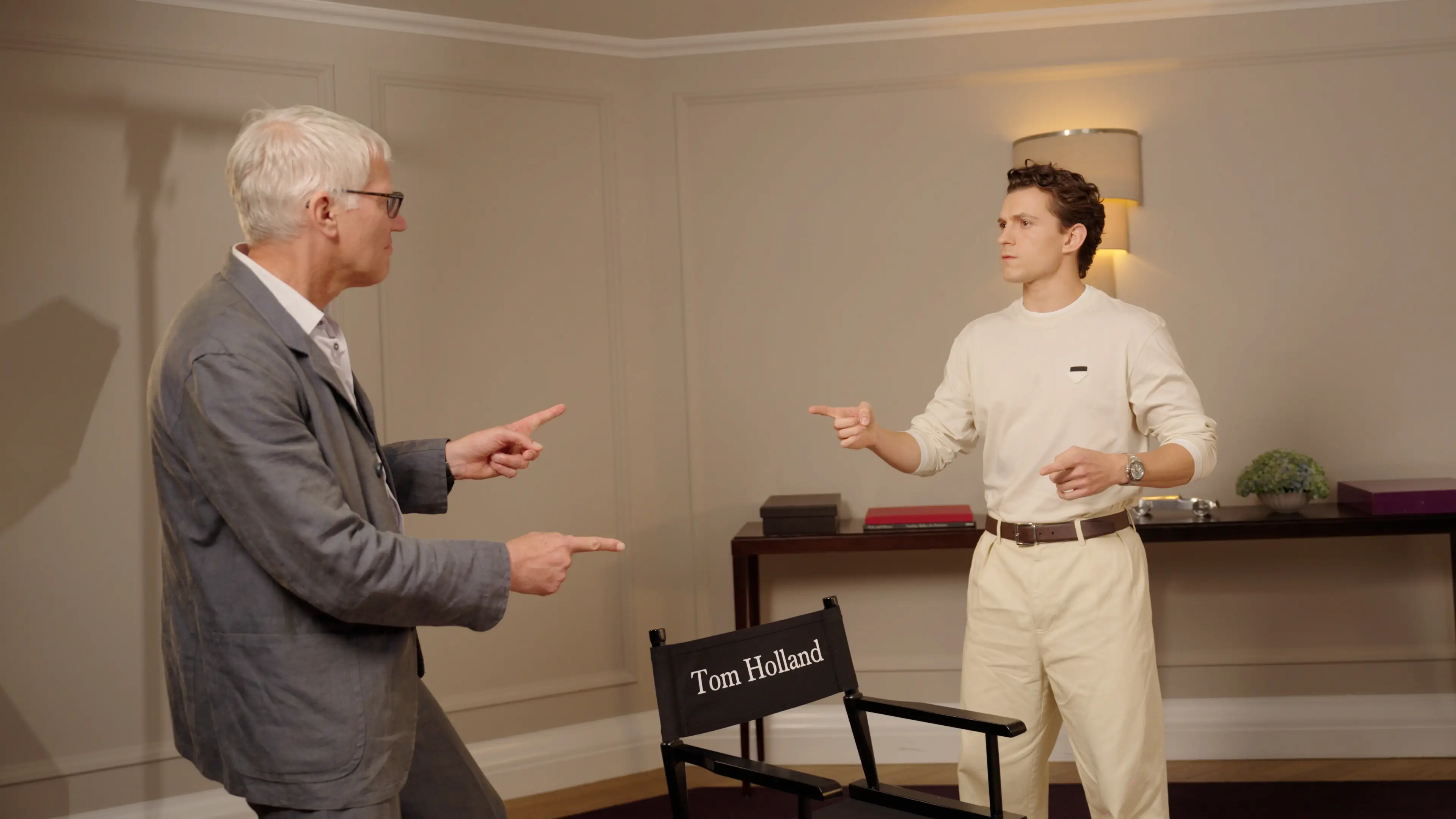 Tom Holland and Tom Holland point at each other