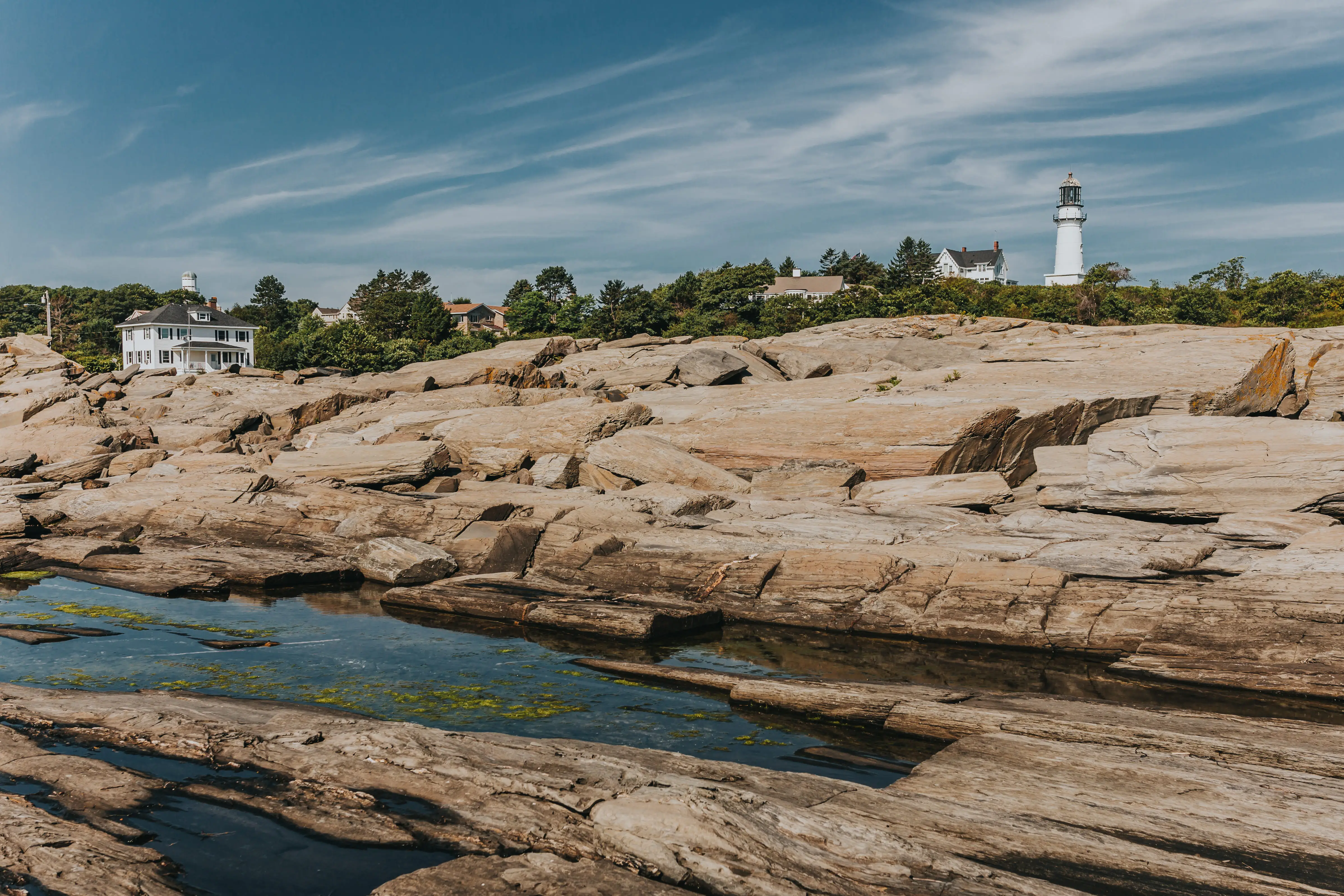 View of rocks, trees, lighthouse