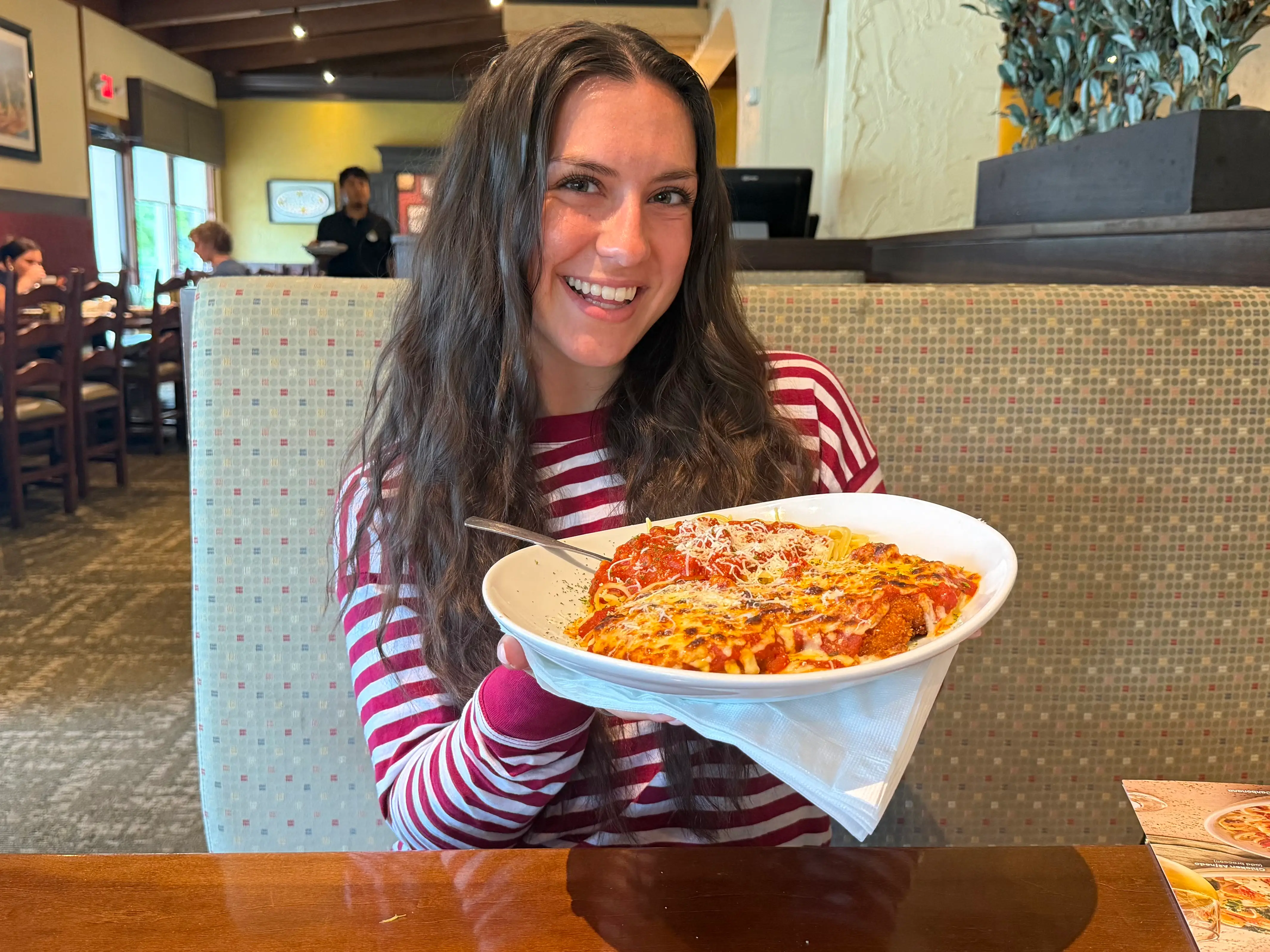 Amanda holds a plate of chicken Parmesan with spaghetti at Olive Garden.