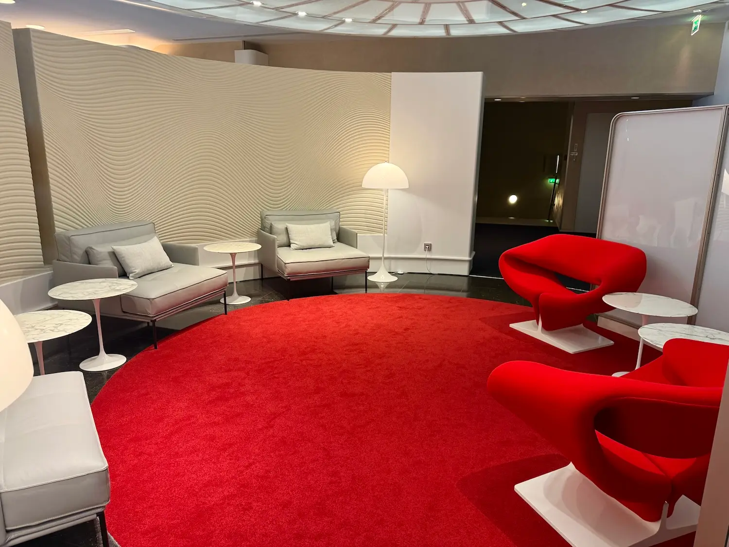 Air France's La Première First Class lounge seating area with red rug, red and white seats