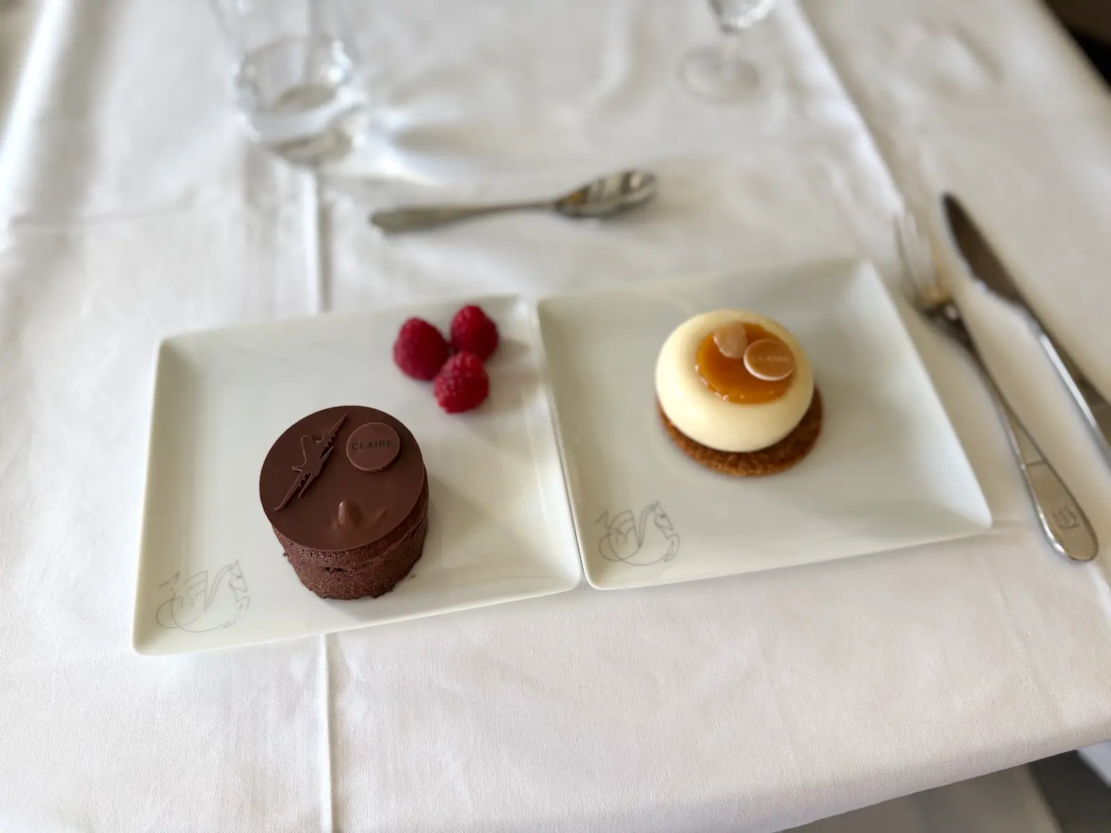 Plates with mousse and chocolate lava cake on white table cloth on flight