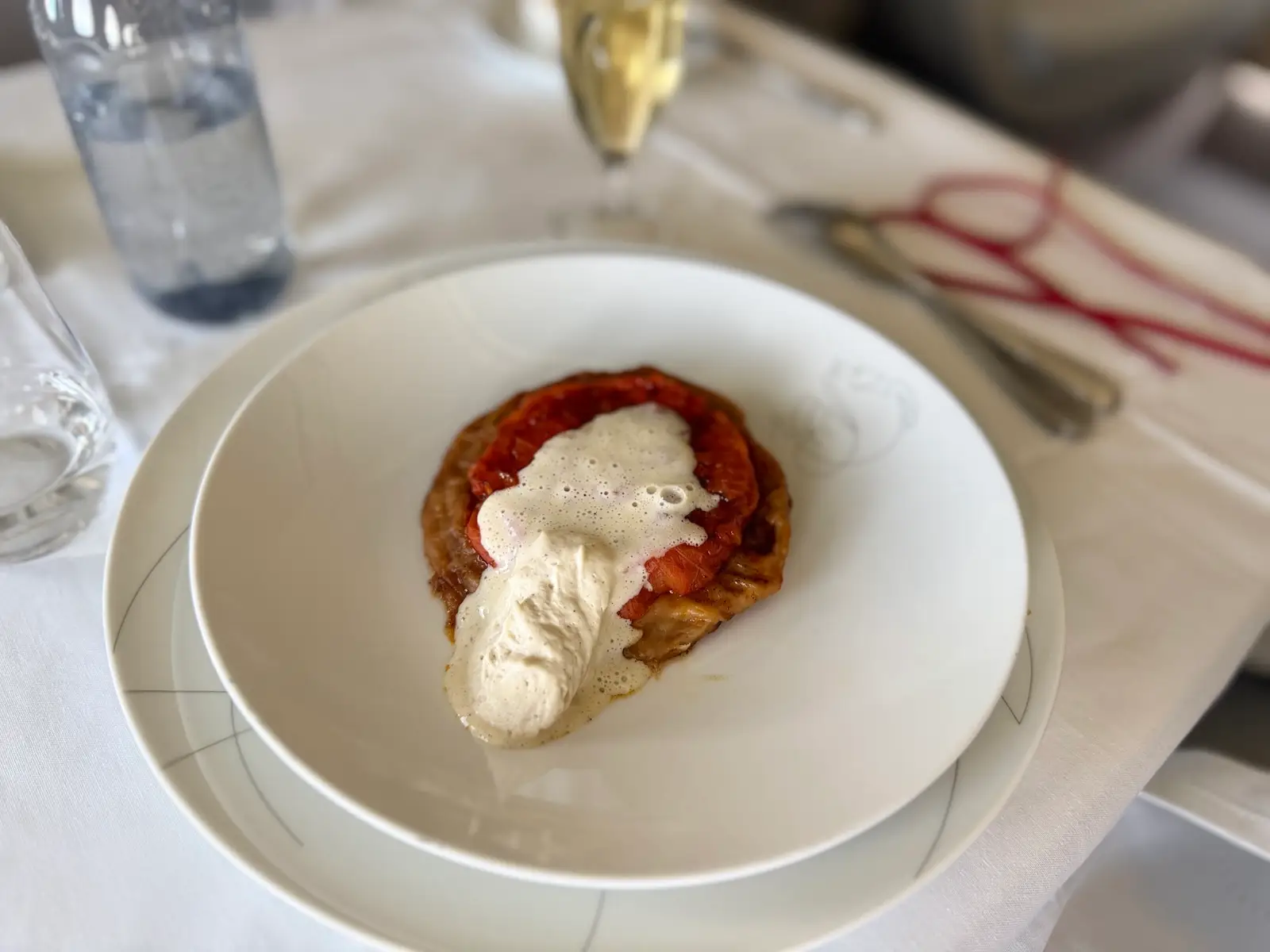 Tomato and smoked vanilla tarte tatin, goat cheese cream on plane tray table