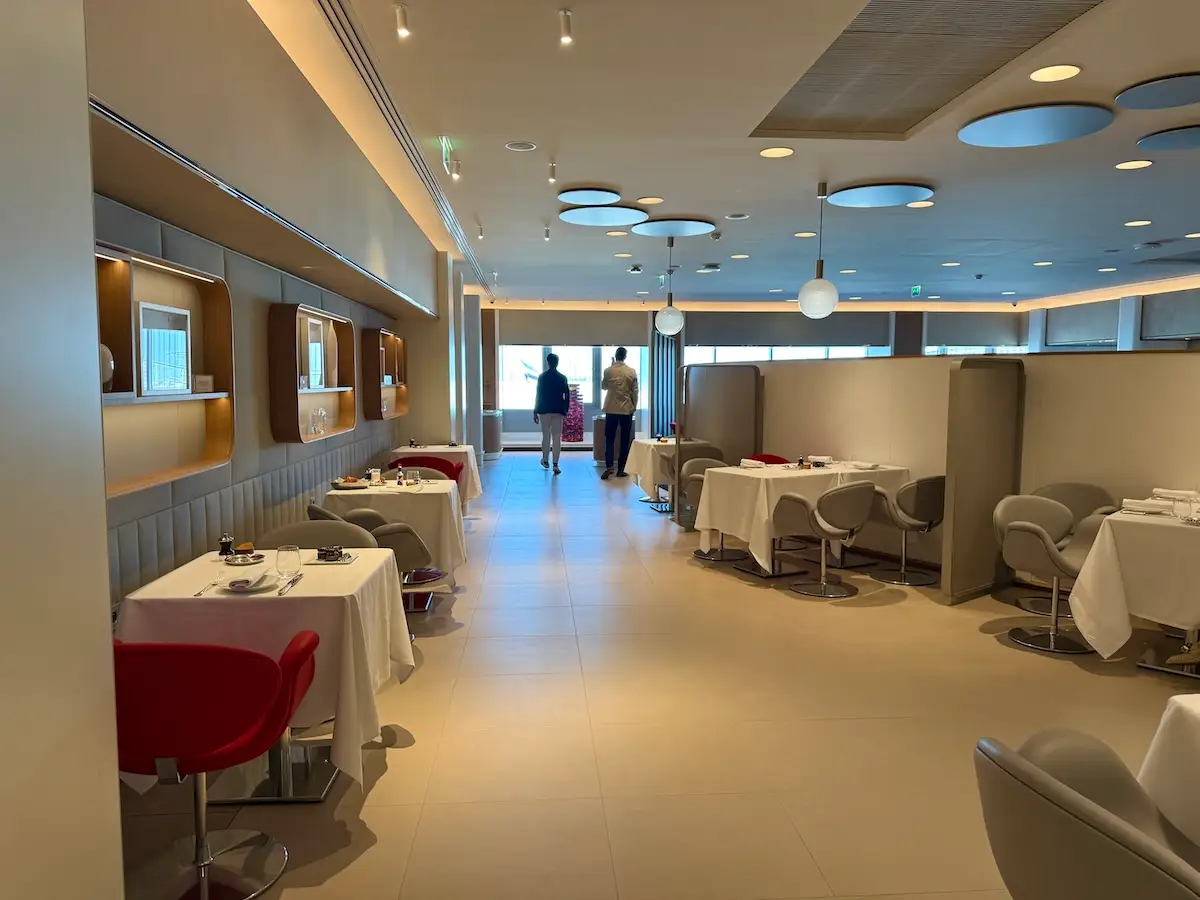 mostly empty dining room area with white tablecloths in Air France's La Première First Class lounge
