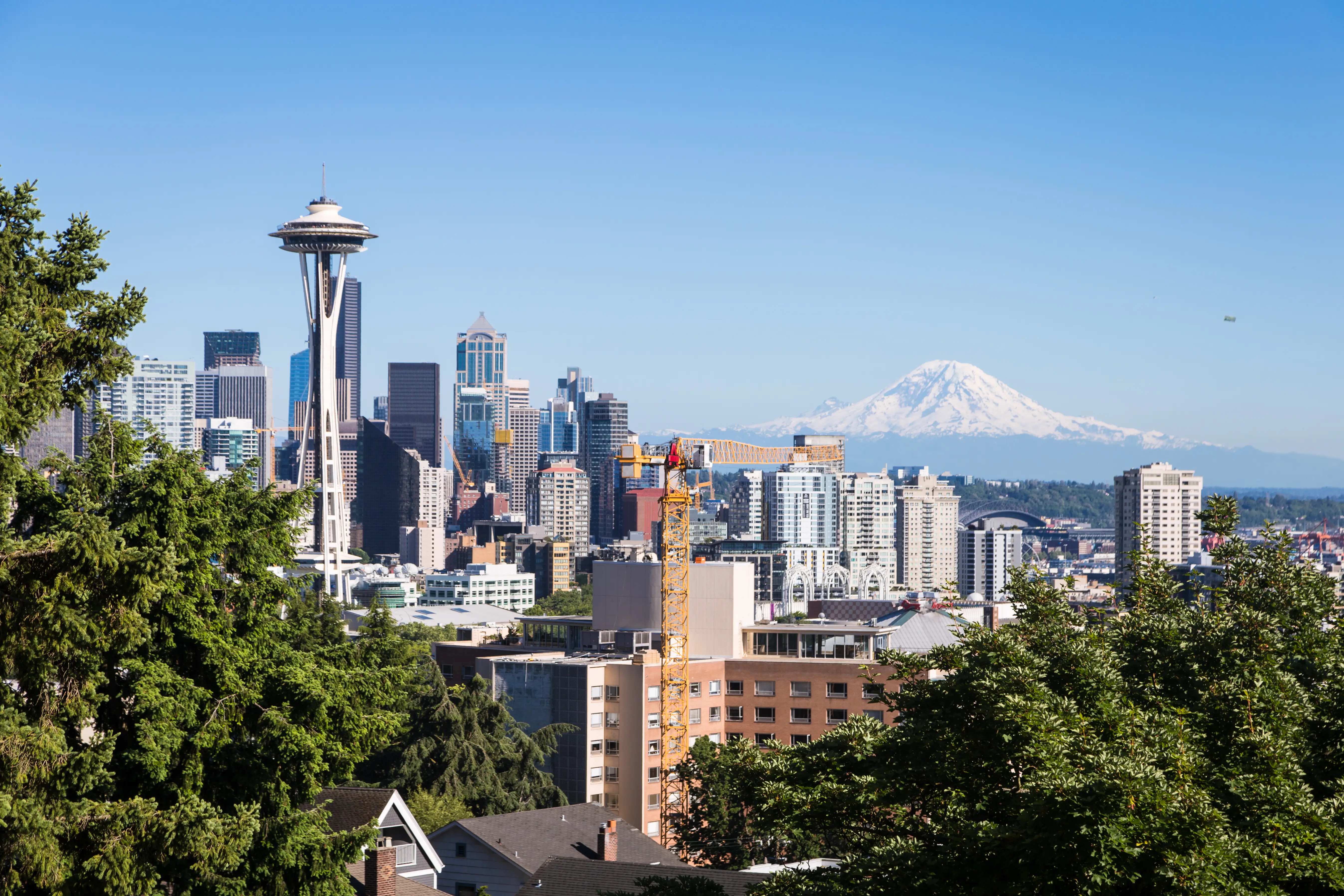 View of Seattle downtown district with the famous Space Needle tower and Mount Rainier.