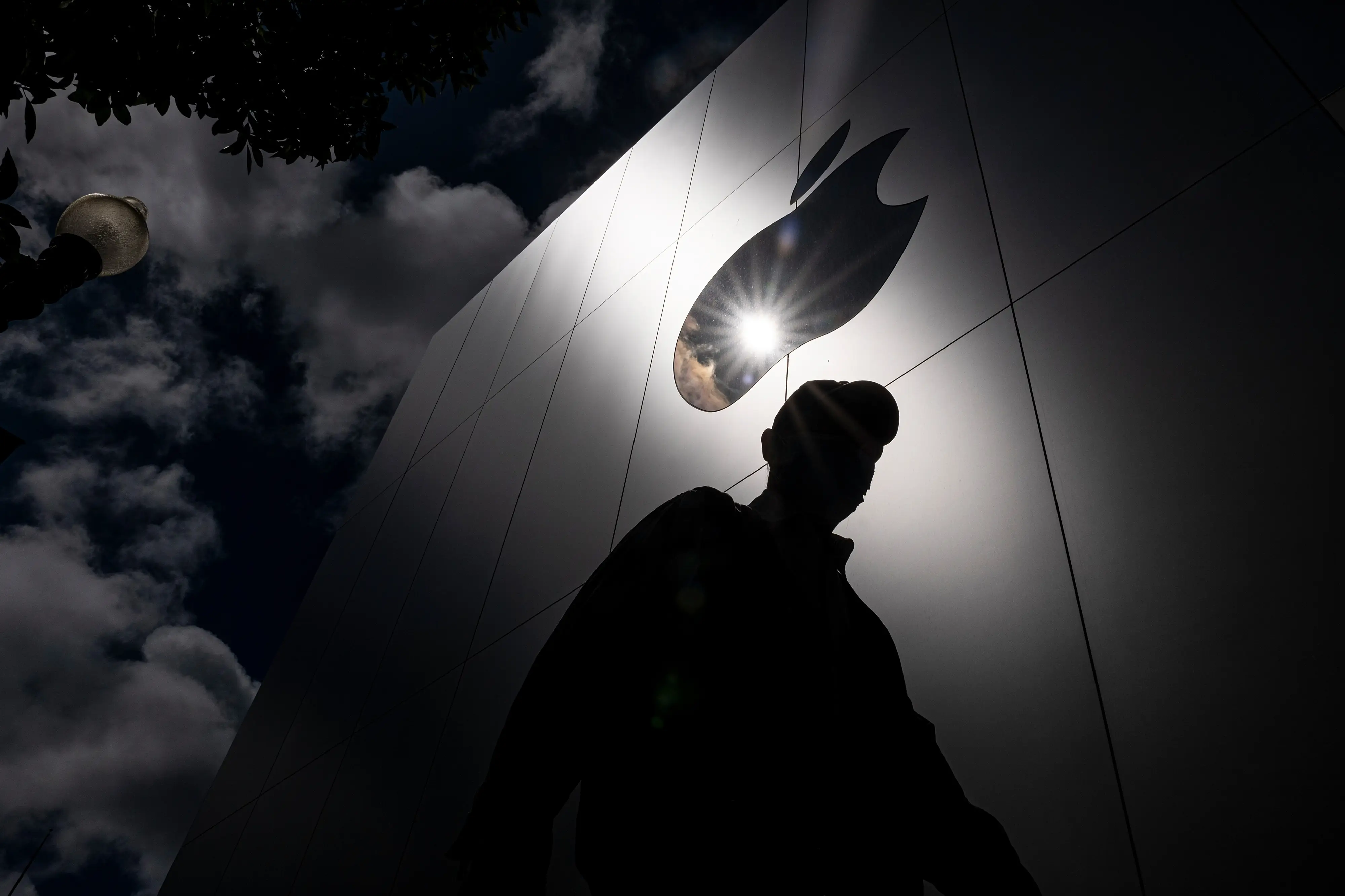 Apple logo and the shadow of a person wearing a hat