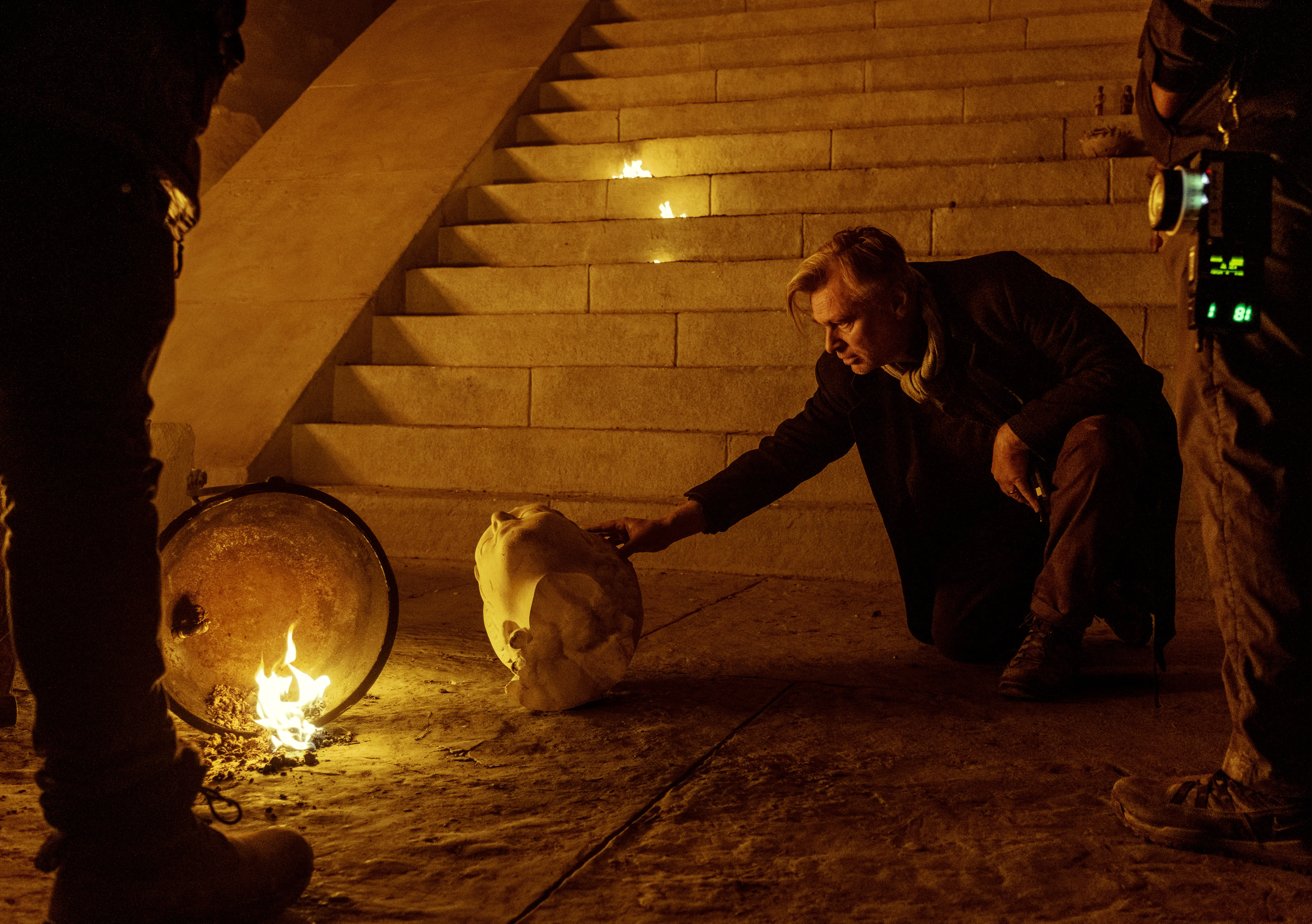 Christopher Nolan touching a marble head on movie set The Odyssey