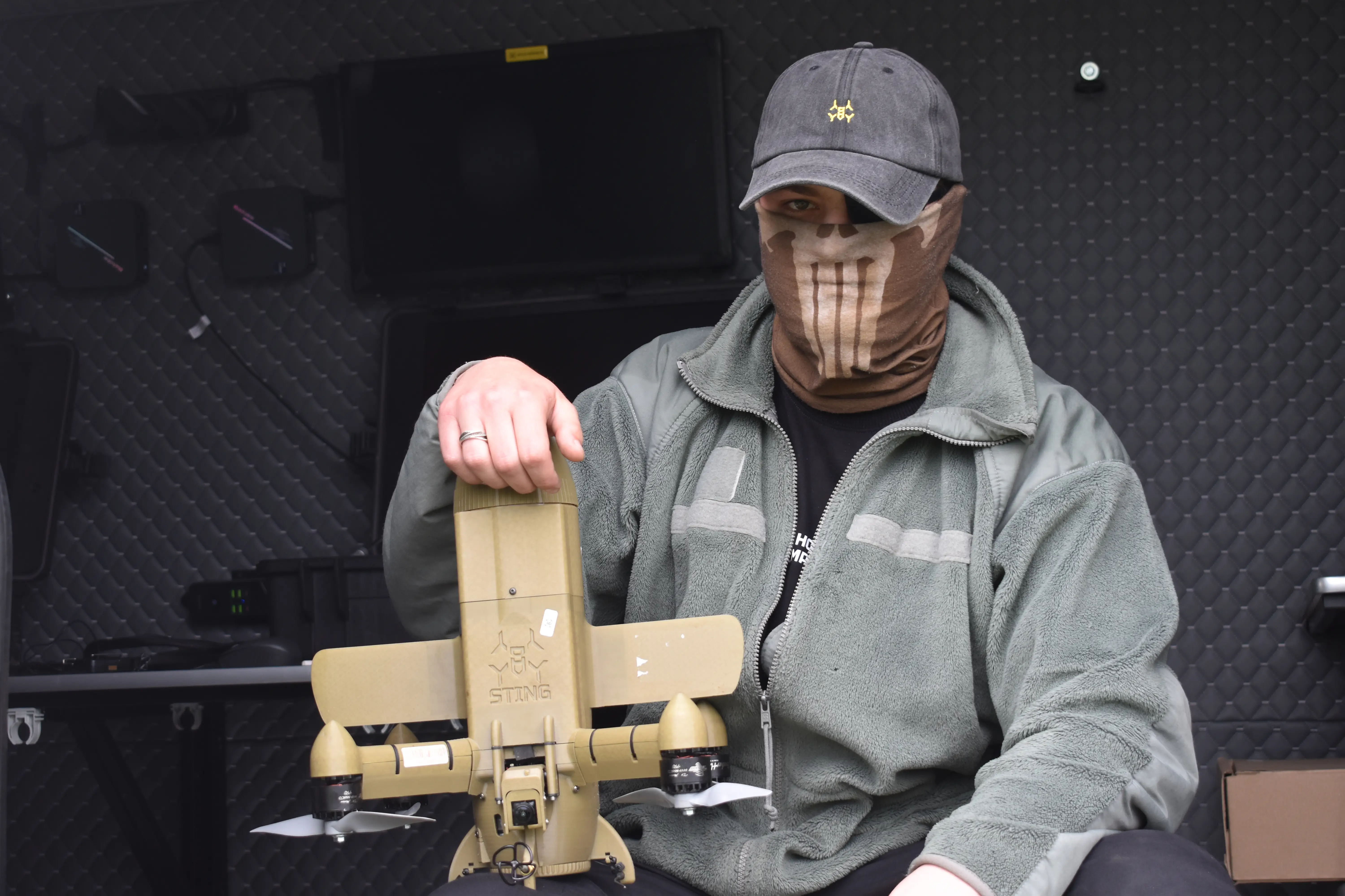 A Ukrainian instructor holds up an interceptor drone.