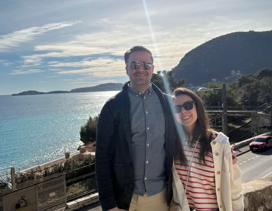 The writer and his partner standing in front of the water in France.