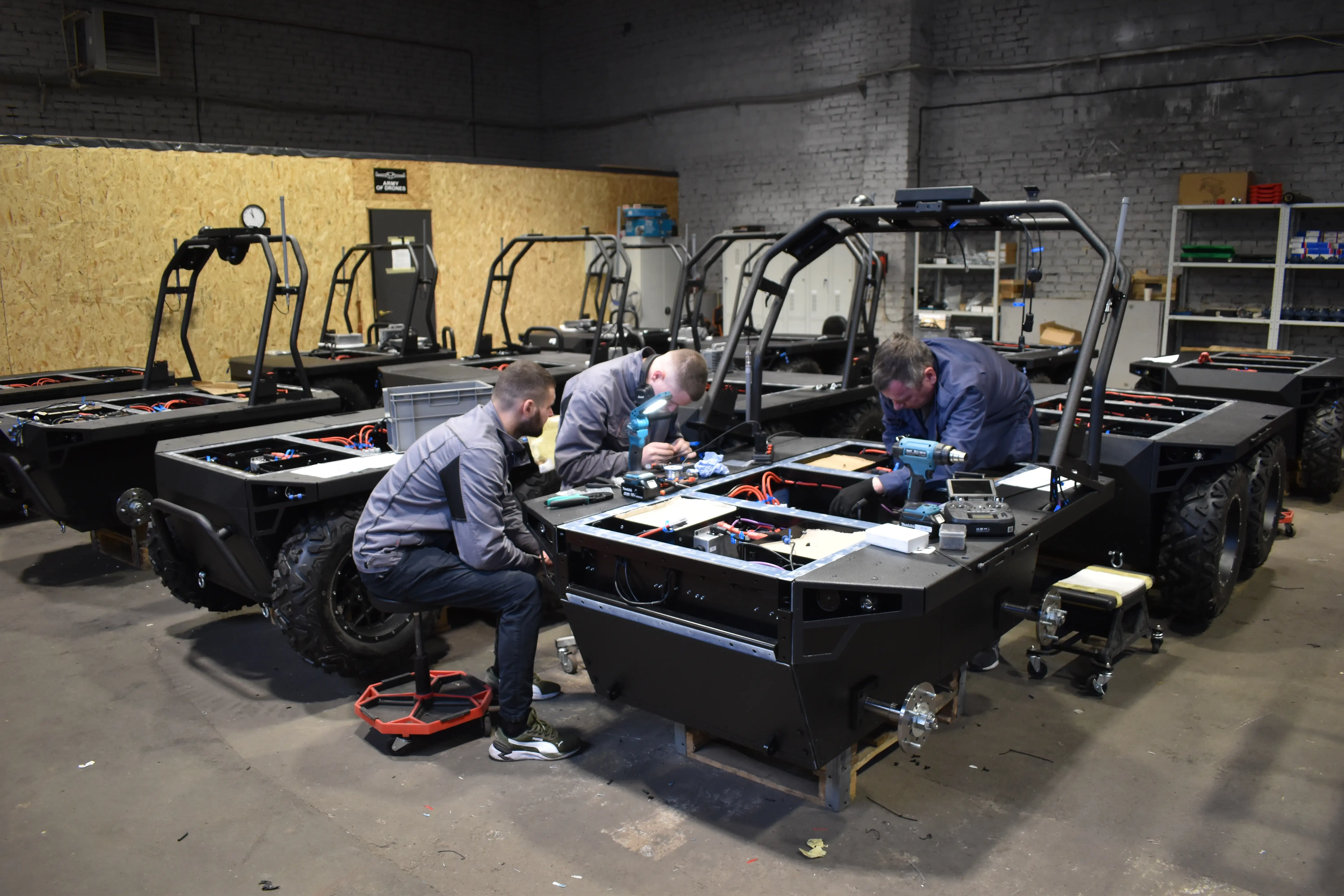 Ukrainian workers attend to a ground robot at a factory.