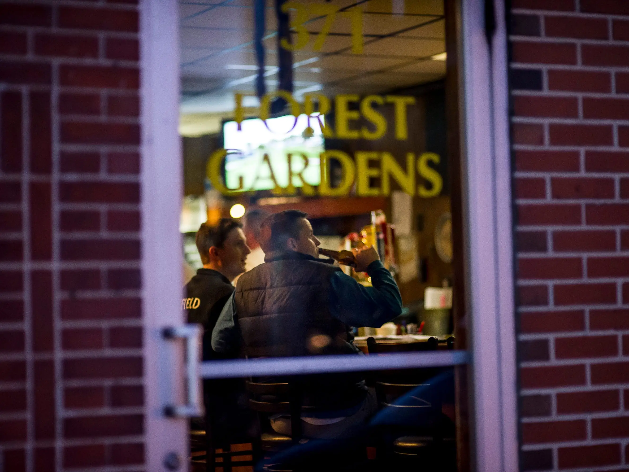 A man drinking a beer inside Forest Gardens bar