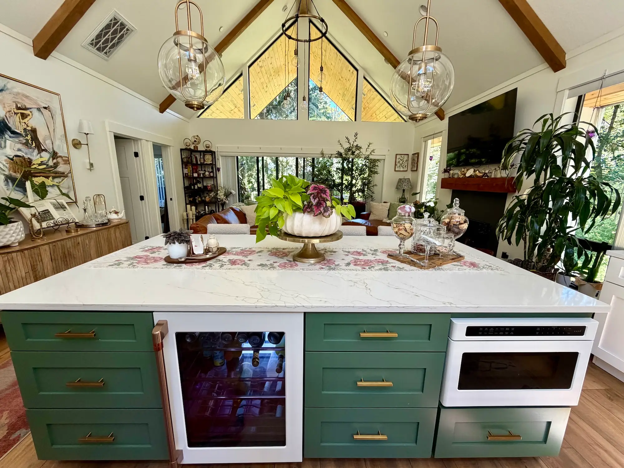 An open concept living area with a large island, a pointed ceiling, and a living space.