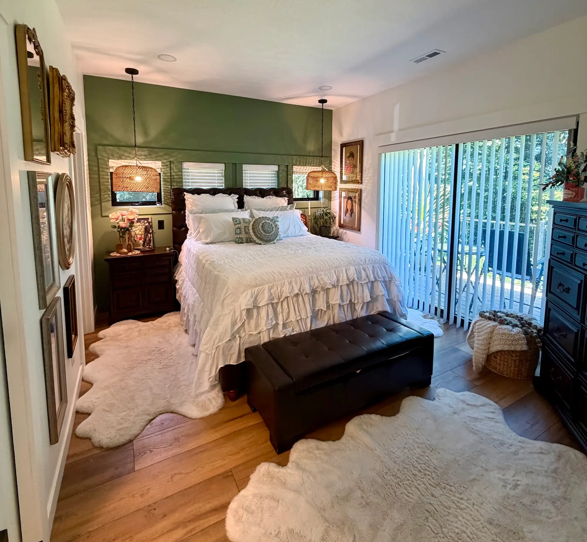 A bedroom with a green wall and a glass door that leads to a patio.