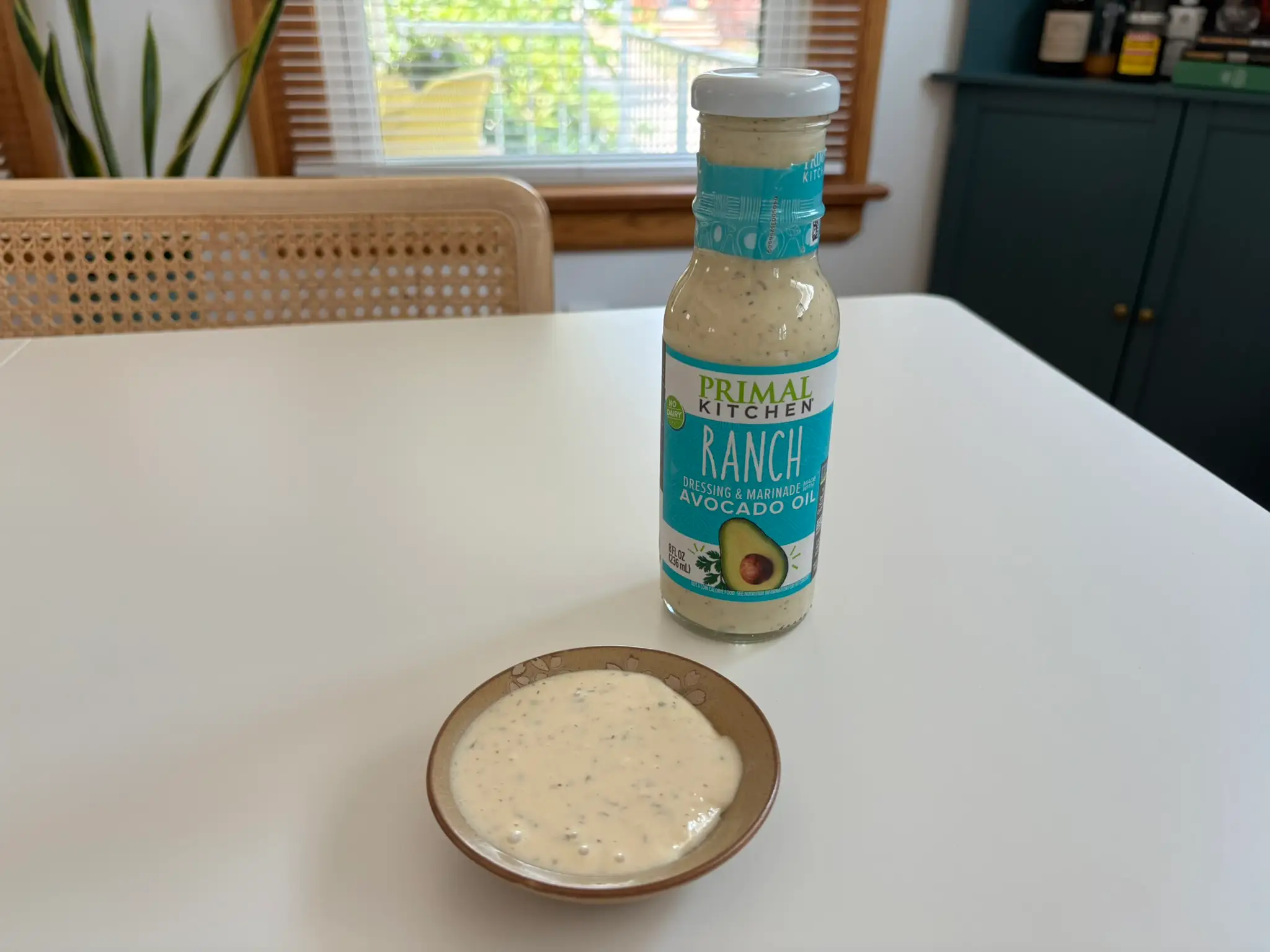 Primal Kitchen  ranch dressing bottle with small bowl of ranch next to it