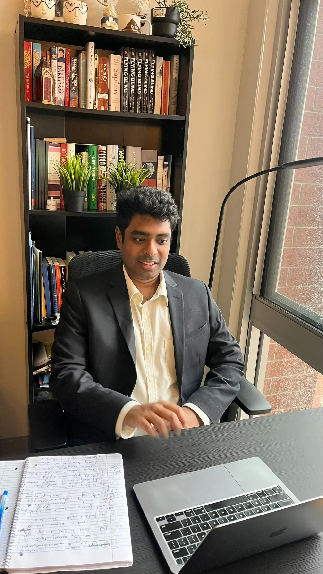 Mohamed Zeeshan is sitting at a desk in front of a laptop