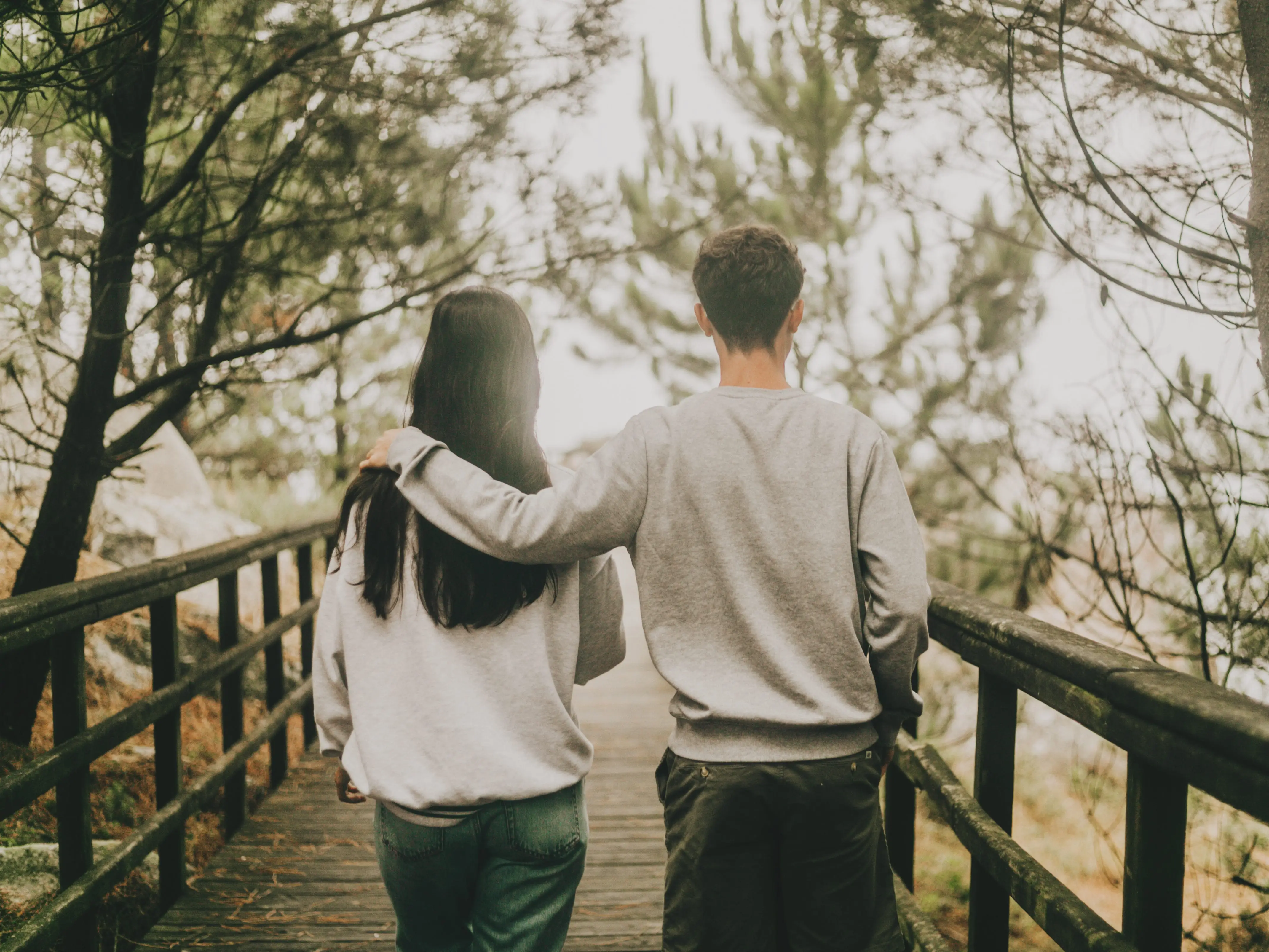 two teenagers walking across a bridge