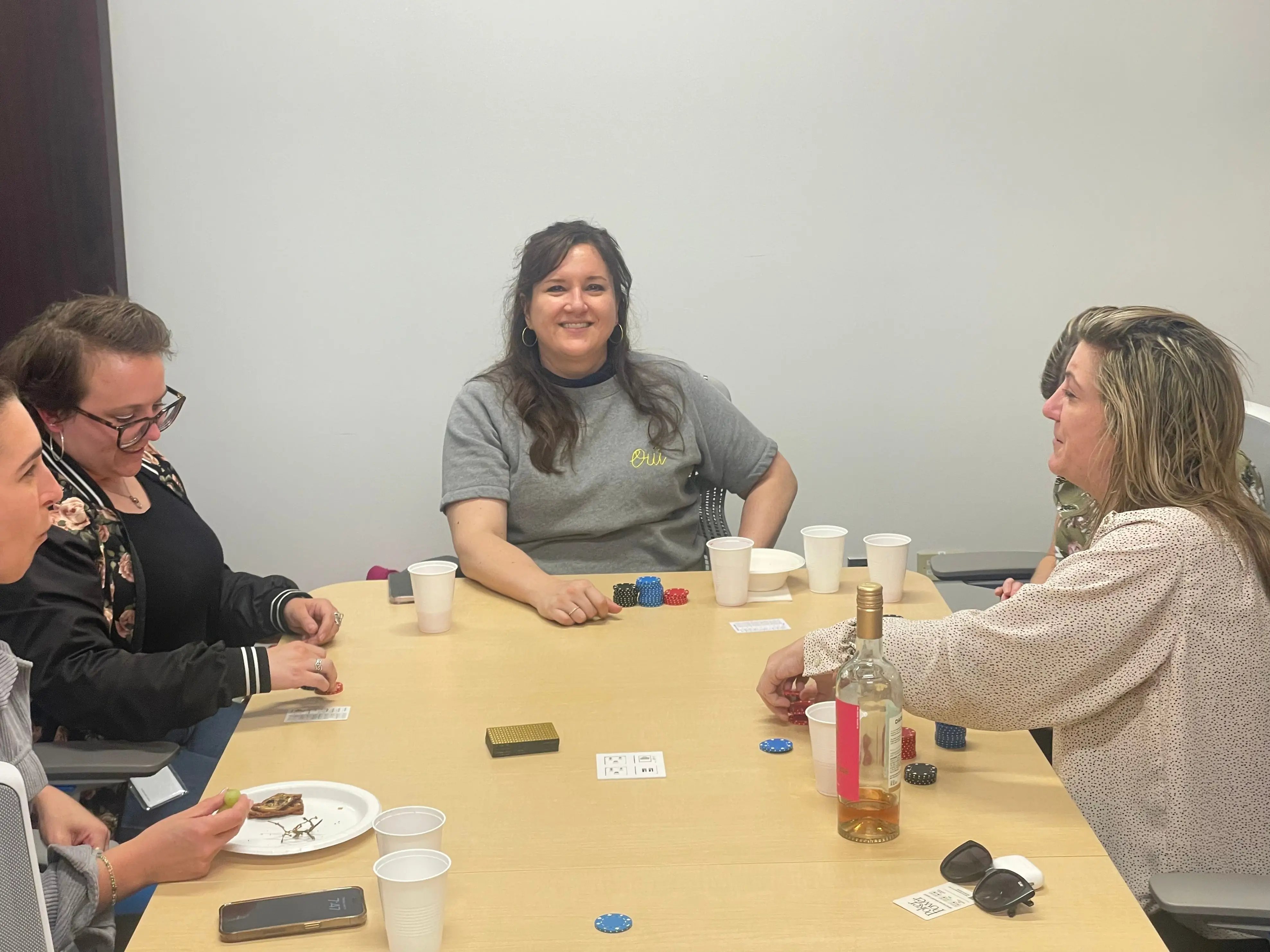 A group of women seated around a conference table playing poker.