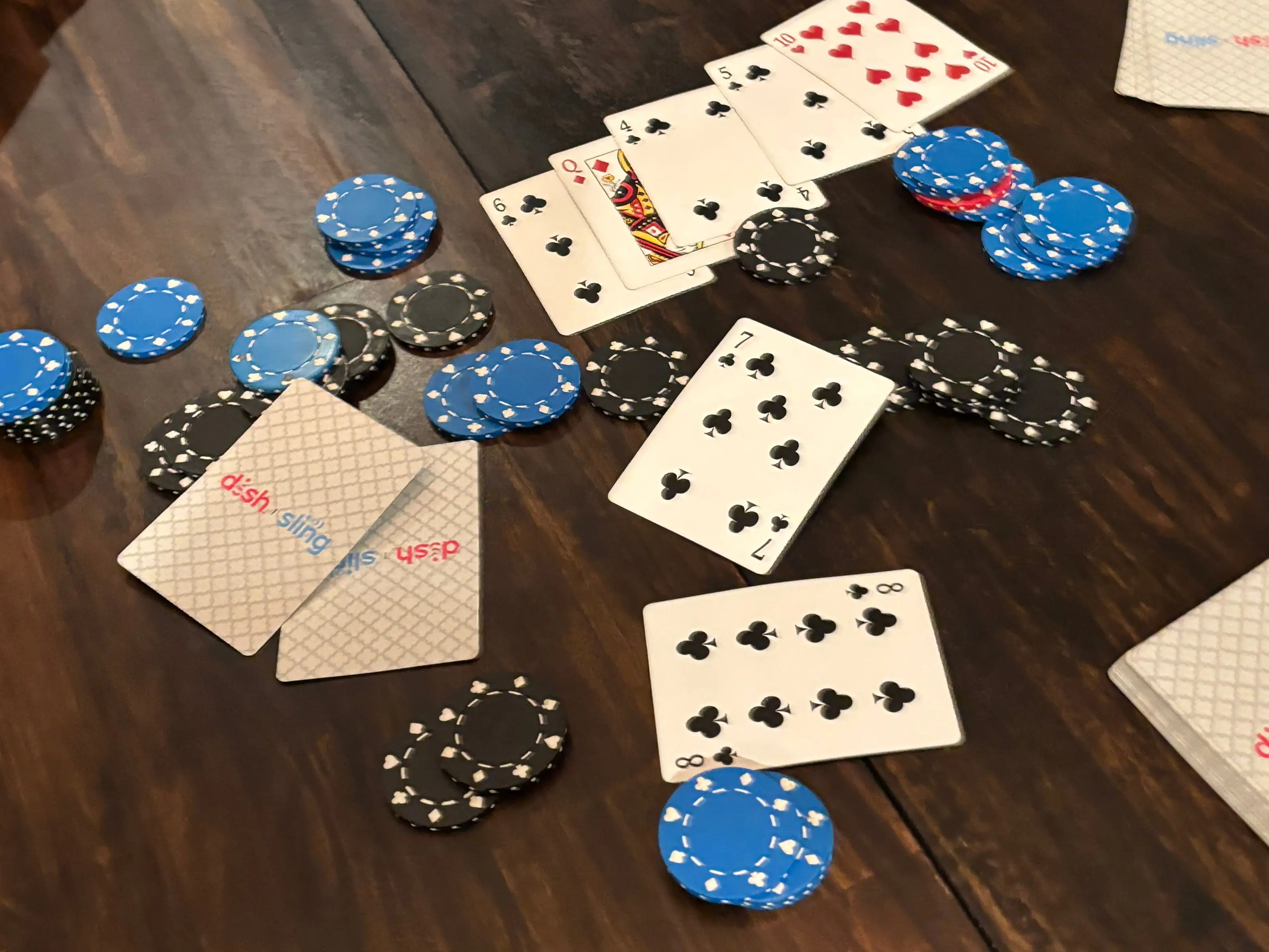 A variety of poker chips and playing cards are spread across a table at an all-female poker night.