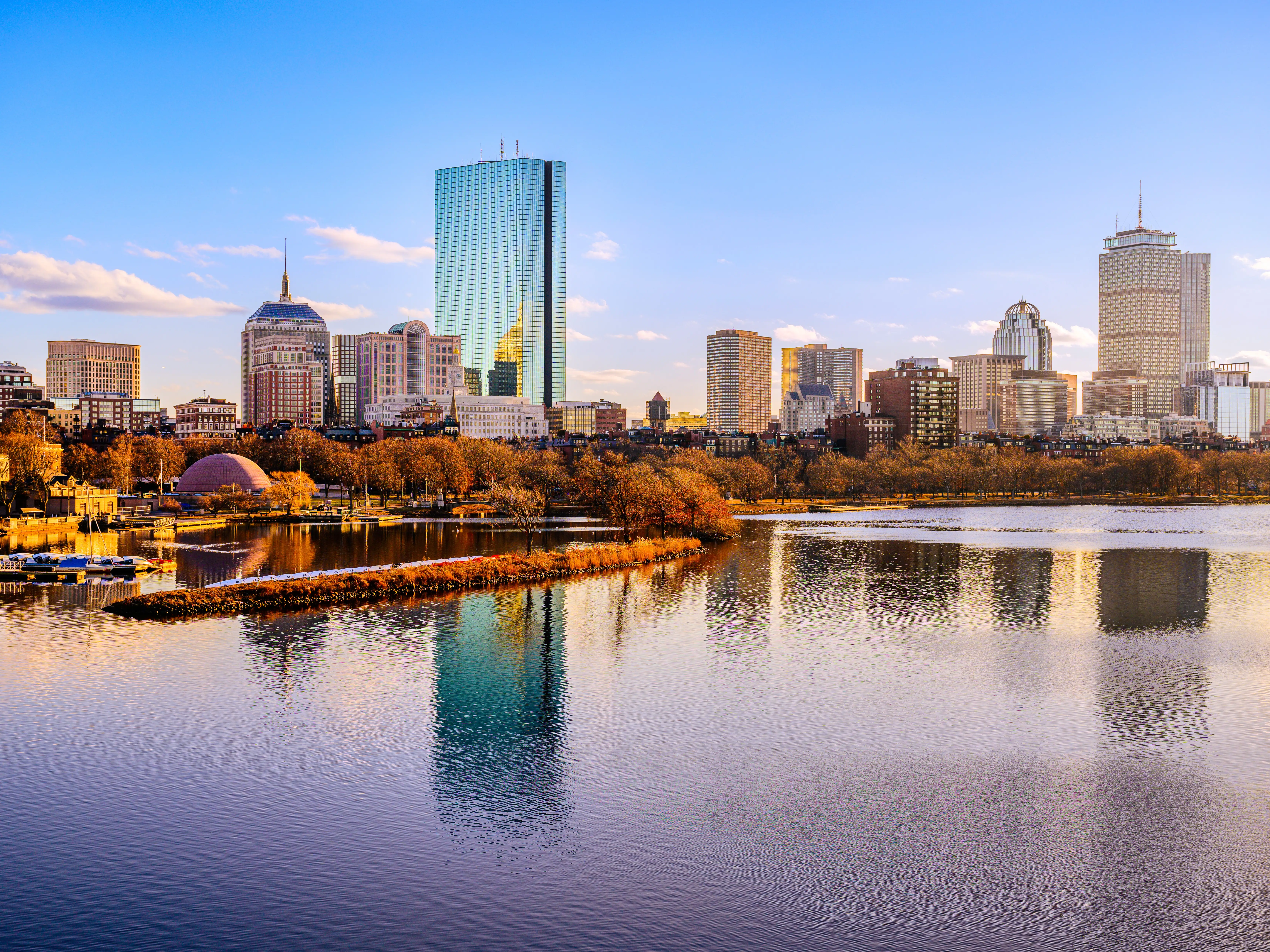 Boston City Skyline over the Charles River in Massachusetts, USA. A tranquil riverscape of Back Bay with golden illuminated wintery foliage in New England. stock photo