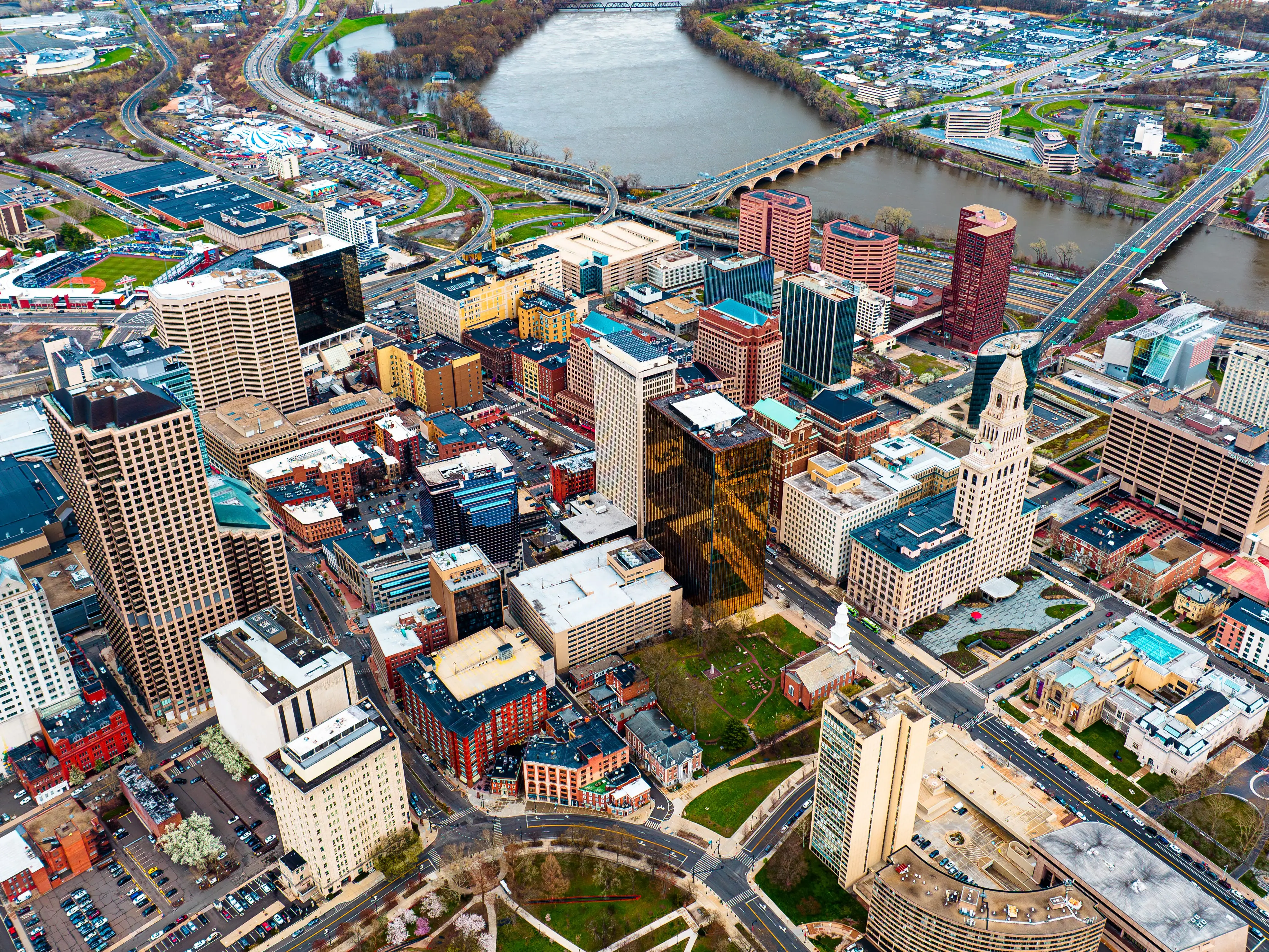 Downtown of beautiful modern Hartford, Connecticut, the USA at daytime. View on the river floating through the city at backdrop. Aerial perspective. stock photo