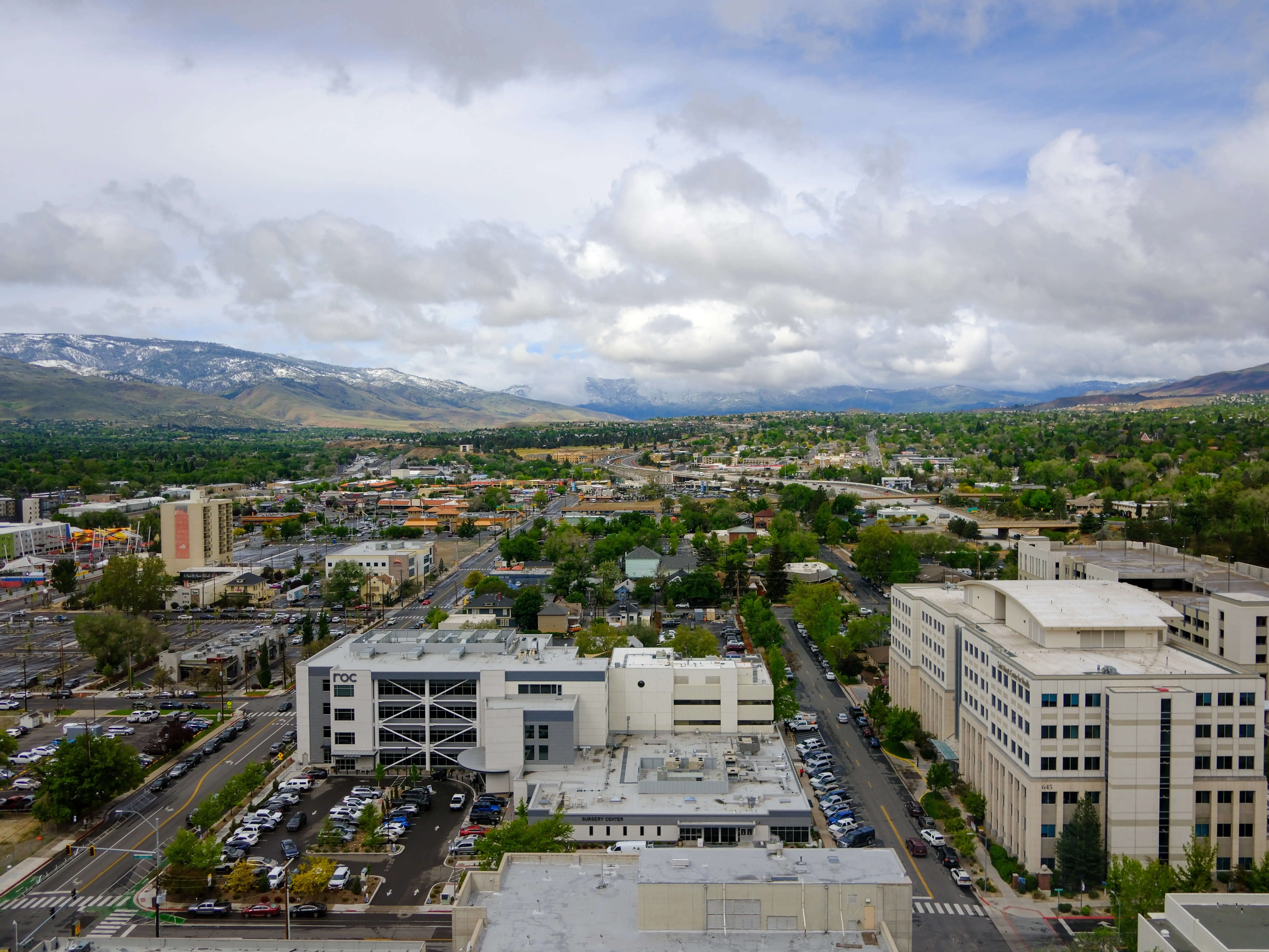 Aerial view of downtown Reno, showing street, highways and mountains in the distance.