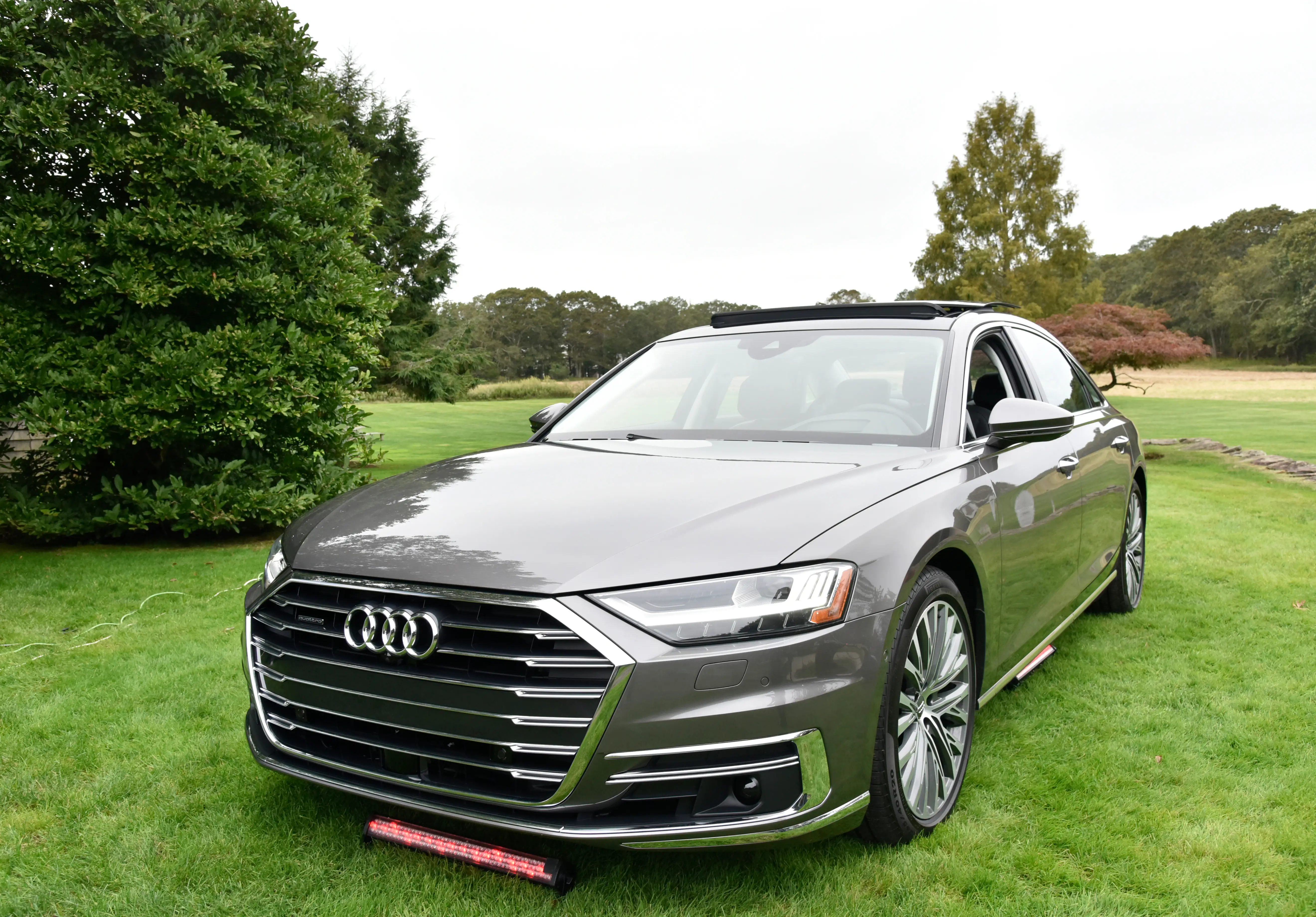 An Audi A8 is parked on a grass lot.
