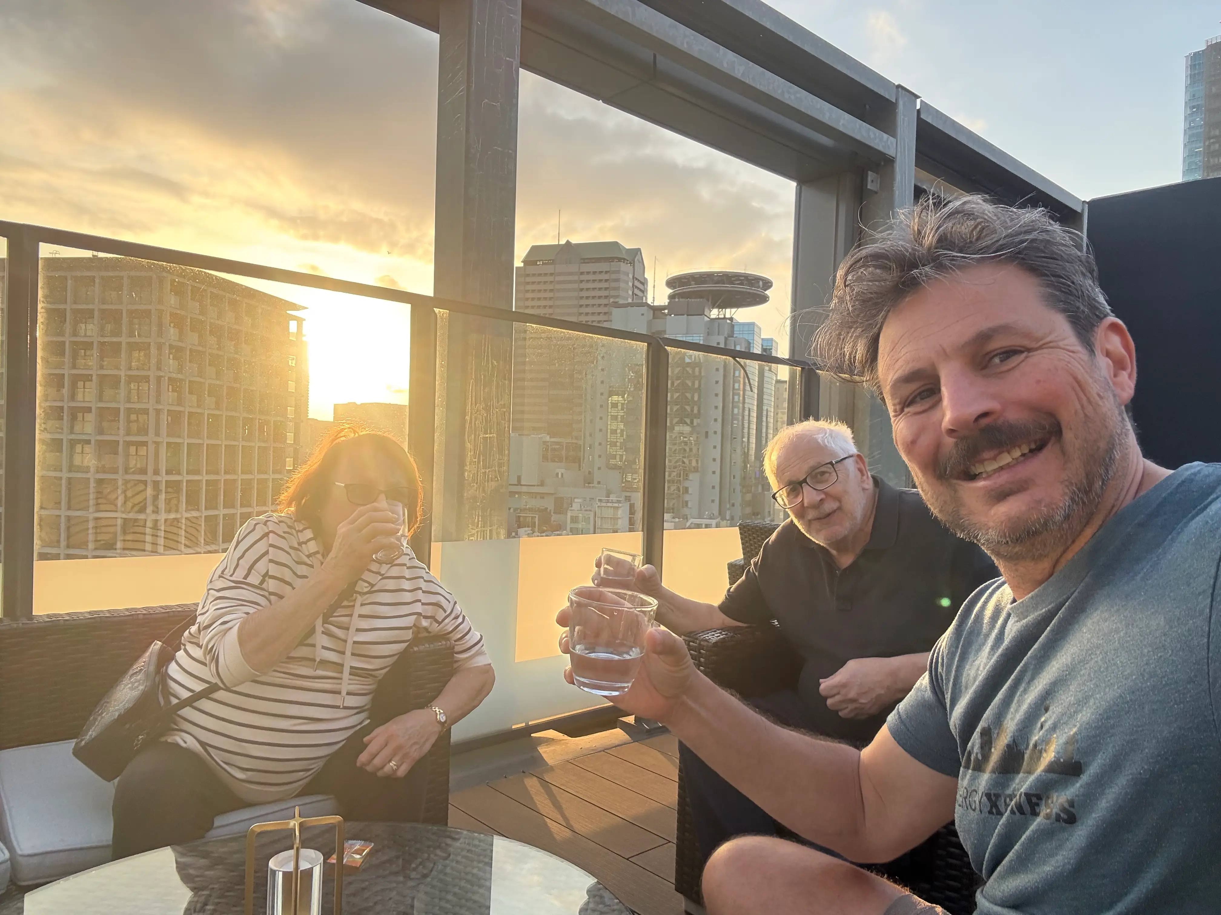 Author Ash Jurberg drinking sake at sunset with his parents