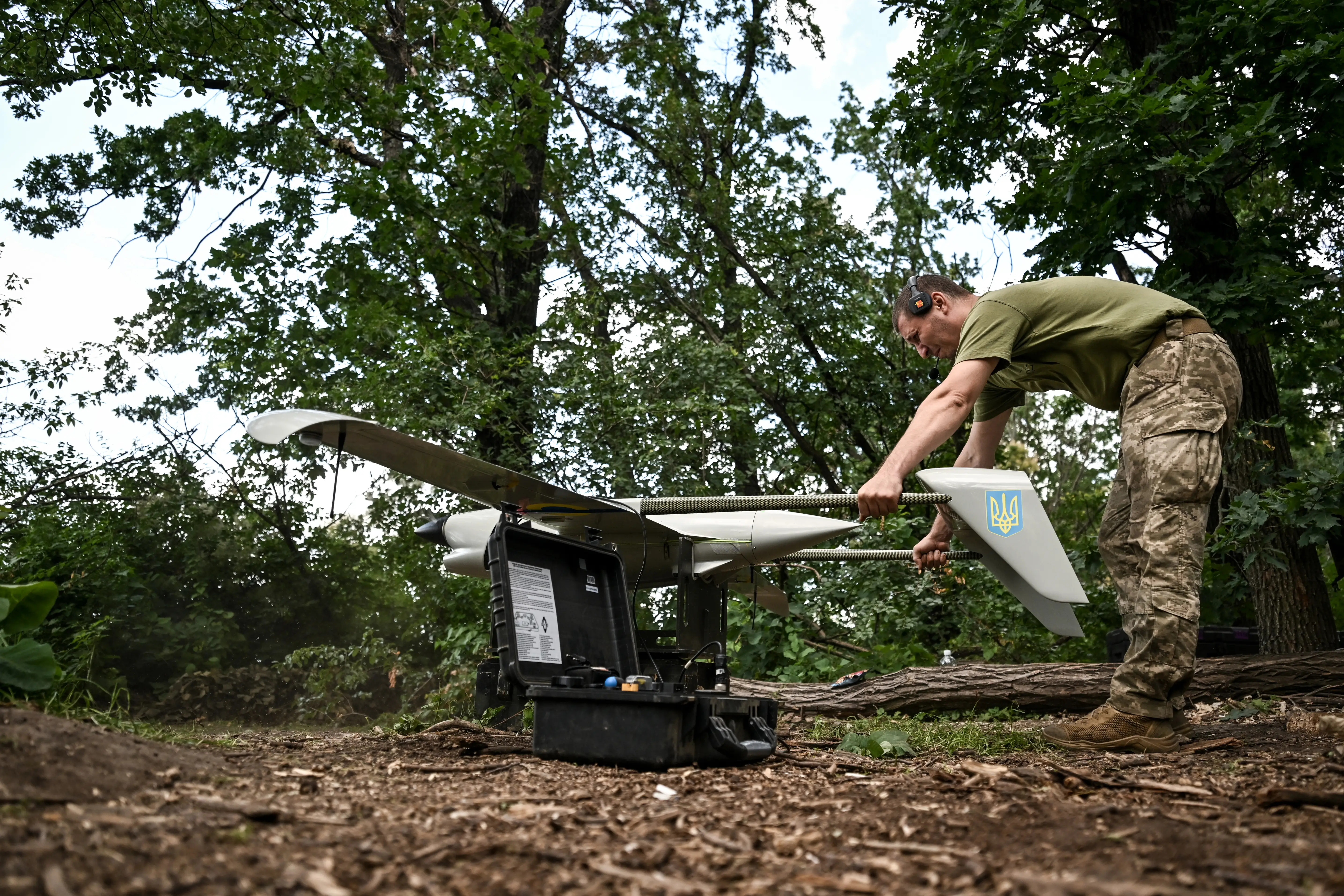 A technician holds a Ukrainian Raybird (ACS-3) UAV as its engine is warmed up before an aerial reconnaissance mission by soldiers from the 148th Separate Artillery Zhytomyr Brigade of the Ukrainian Airborne Forces in the Oleksandrivka sector, Dnipropetrovsk region, Ukraine, on June 22, 2026.