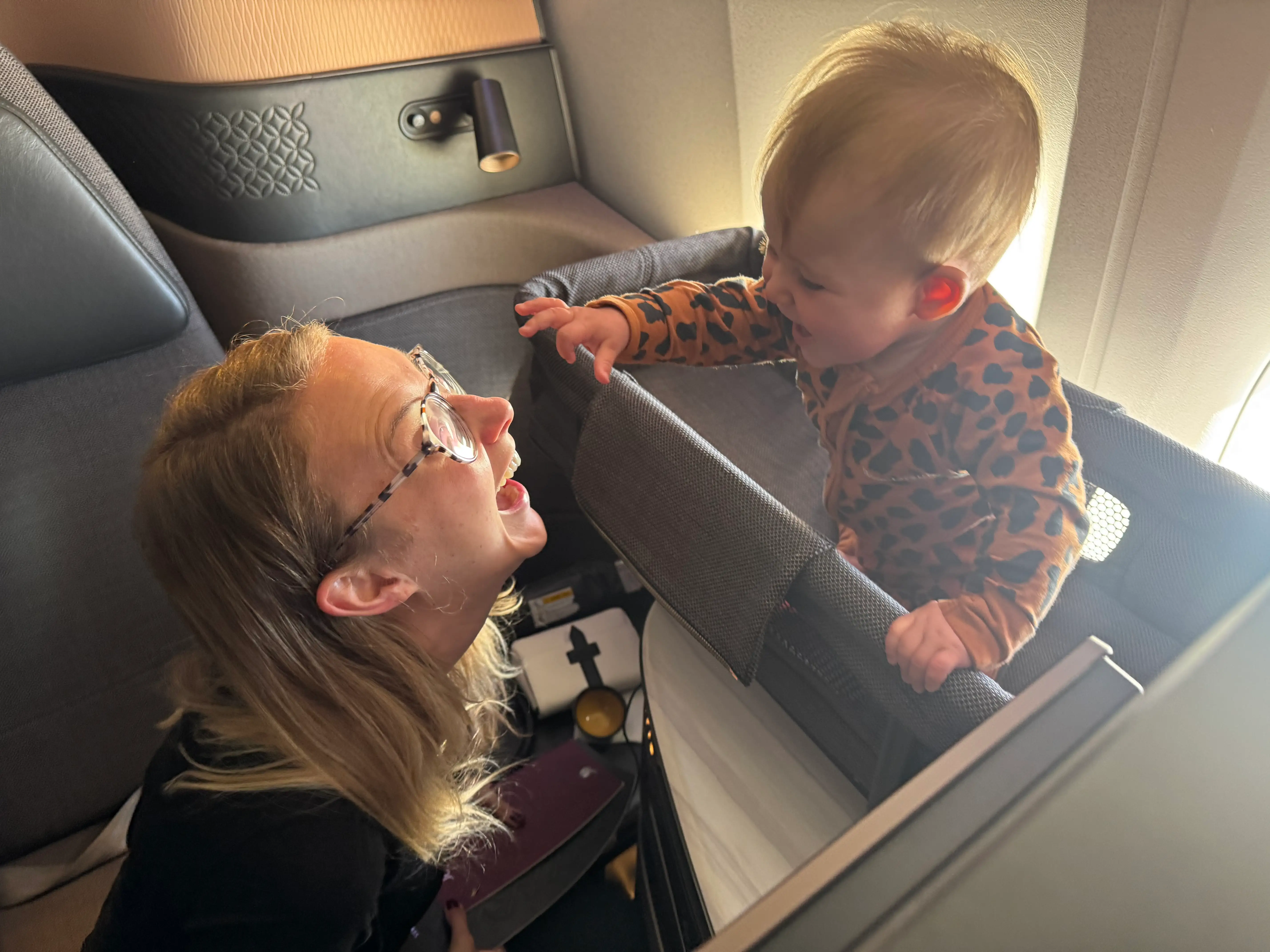 Woman smiling at baby on plane