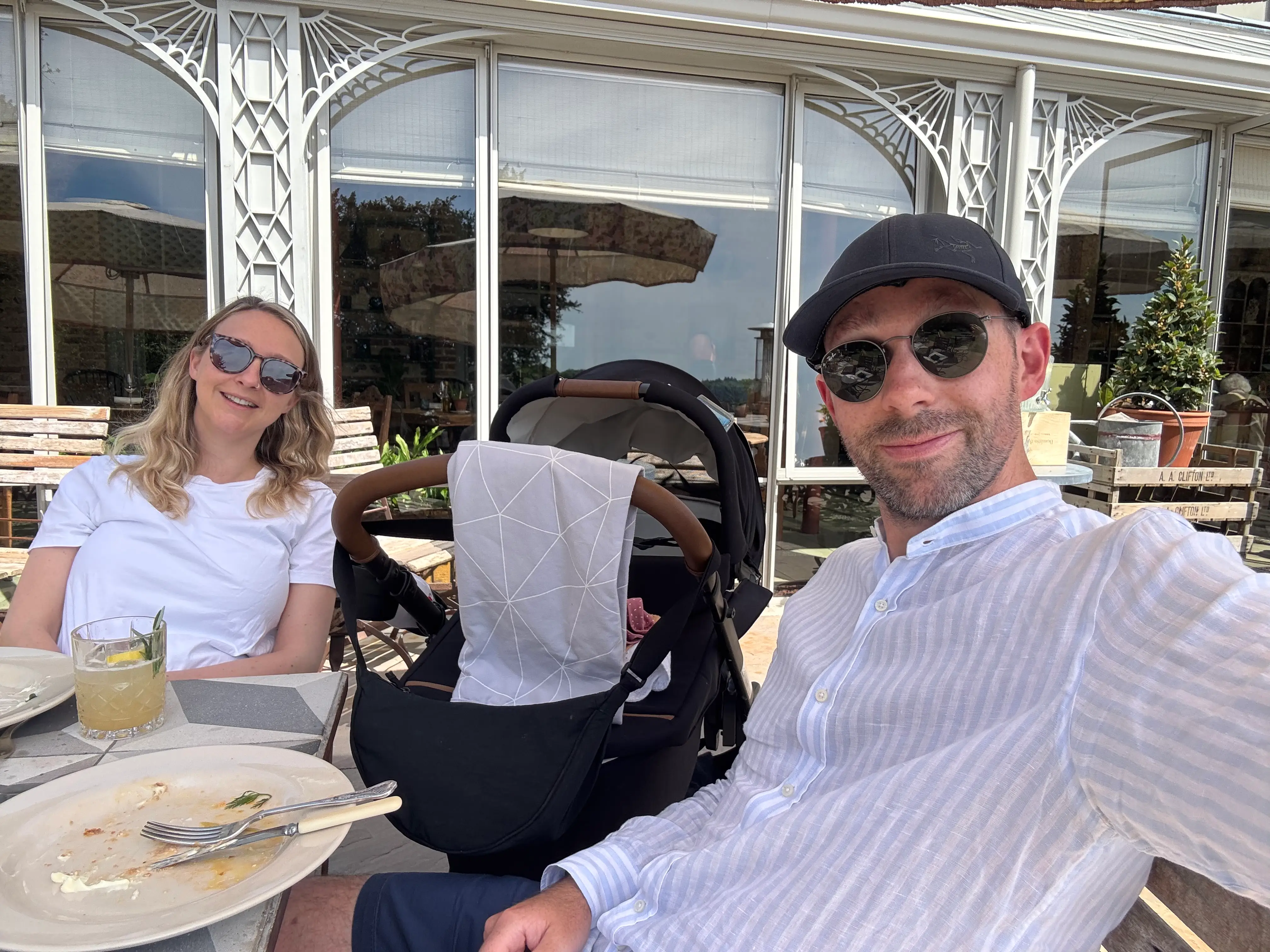 Parents smiling with stroller outside