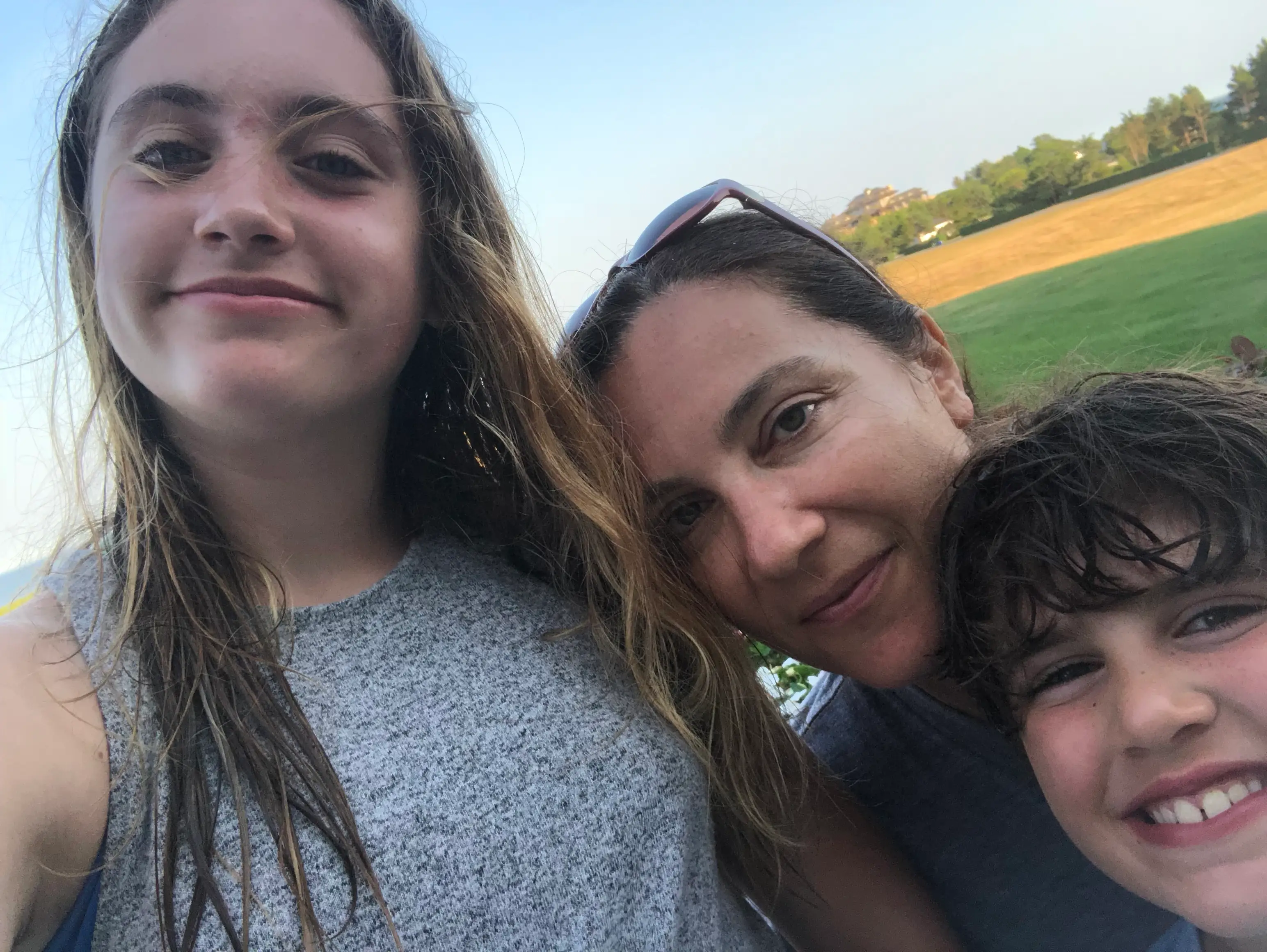 Woman smiling with two kids outside