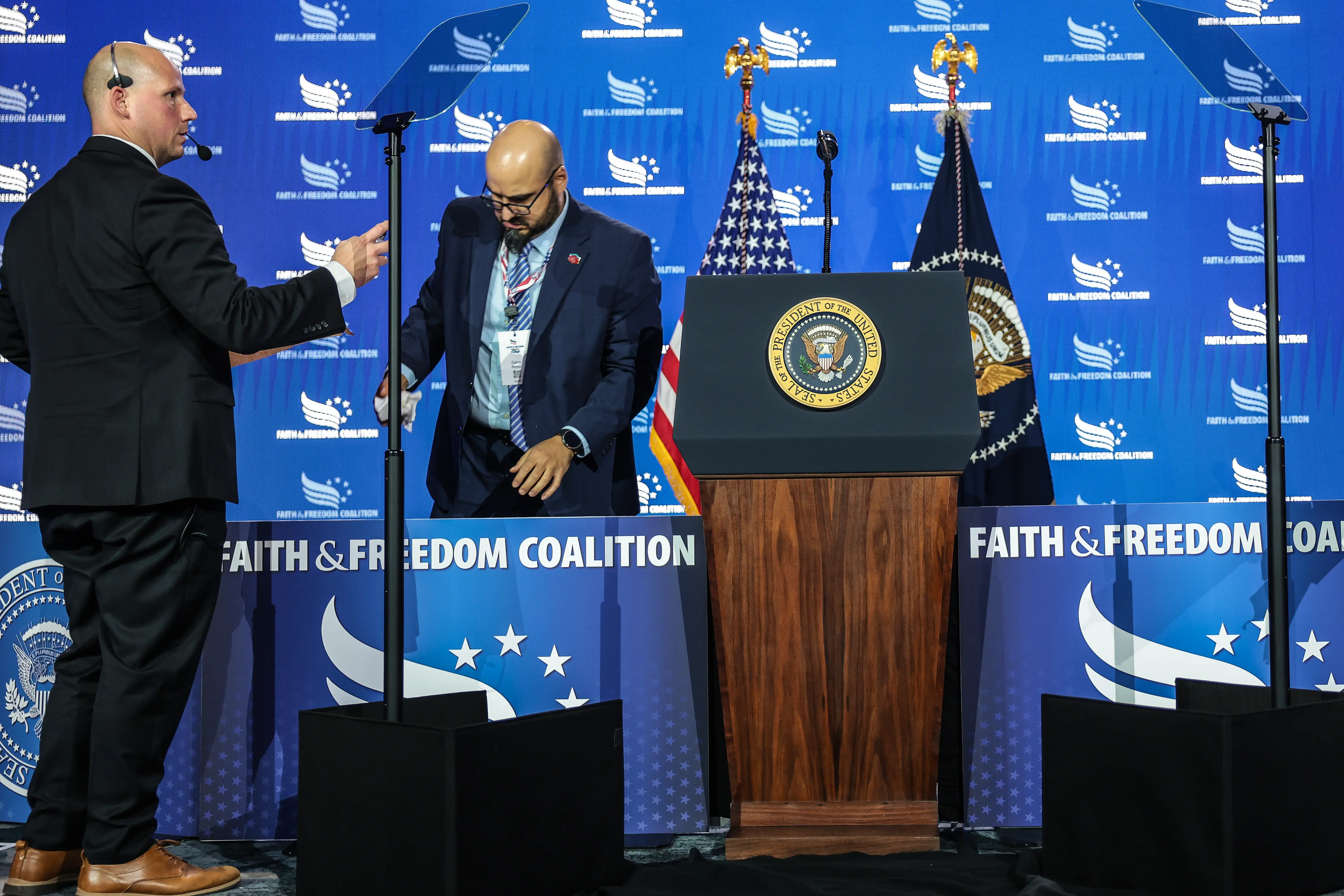 White House teleprompter operator Gabriel Perez (R) sets up a teleprompter before US President Donald Trump speaks.