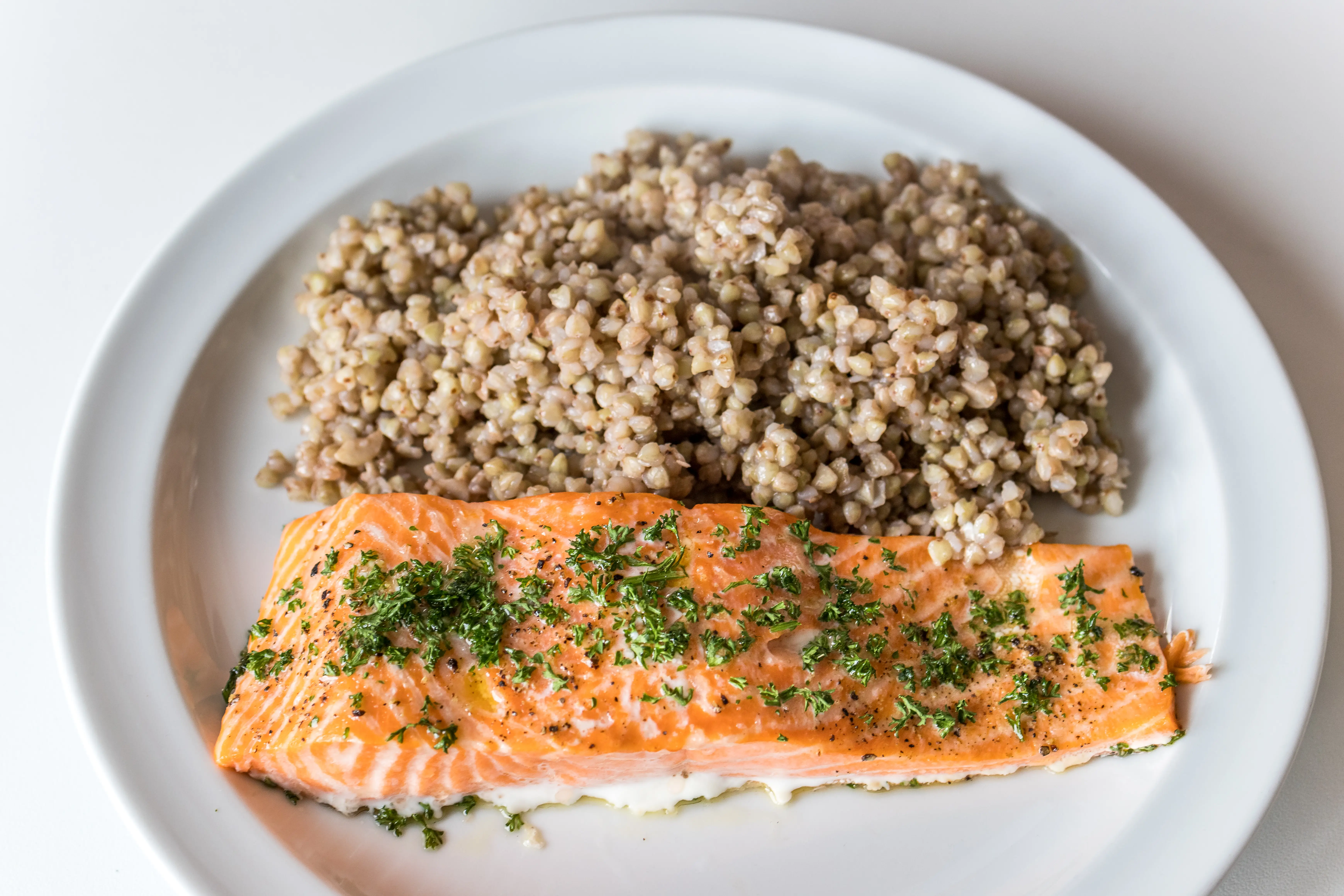 Salmon with herbs on top, grains on the side