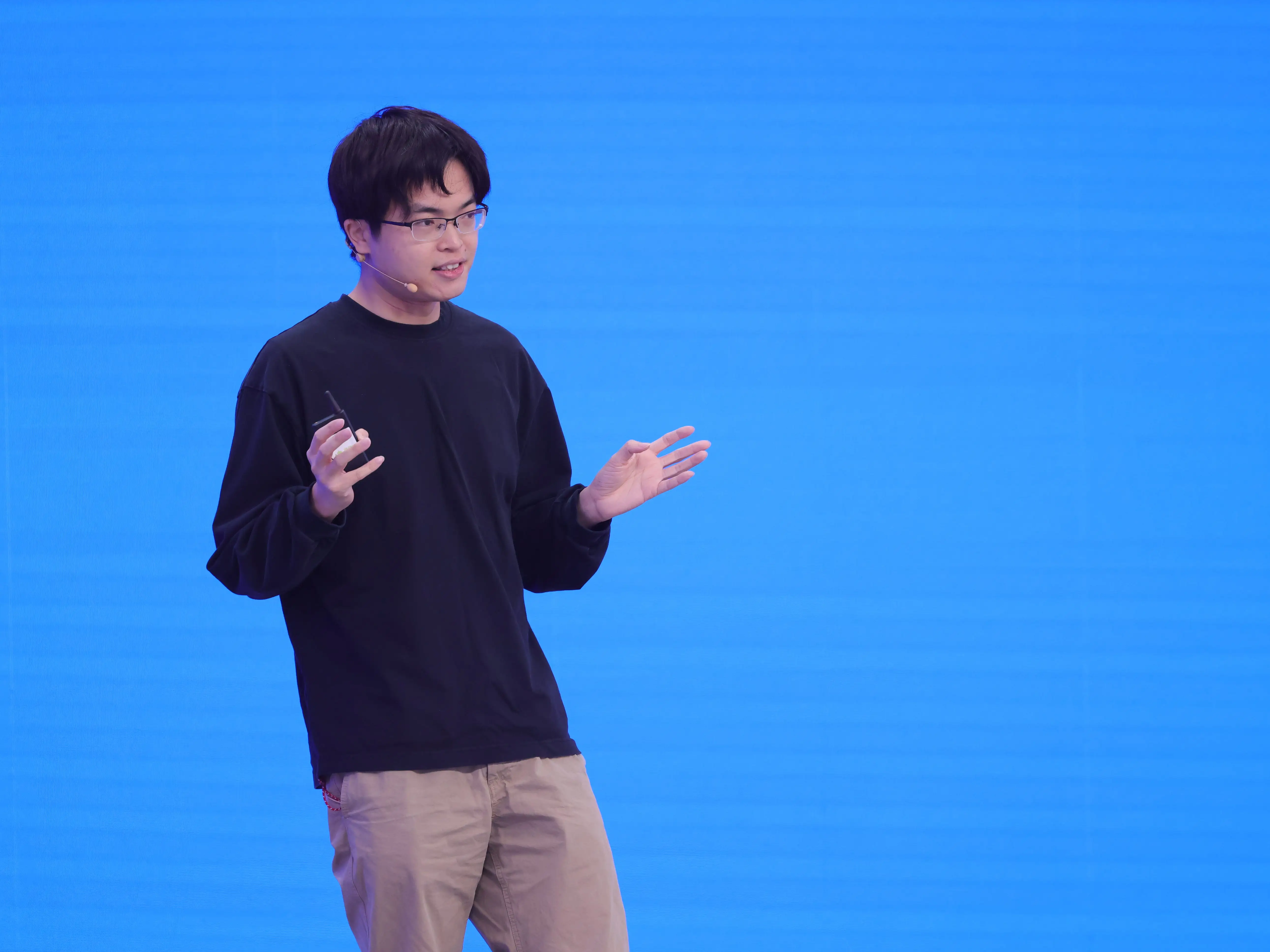 zhilin yang, founder of moonshot ai, stands against a blue background