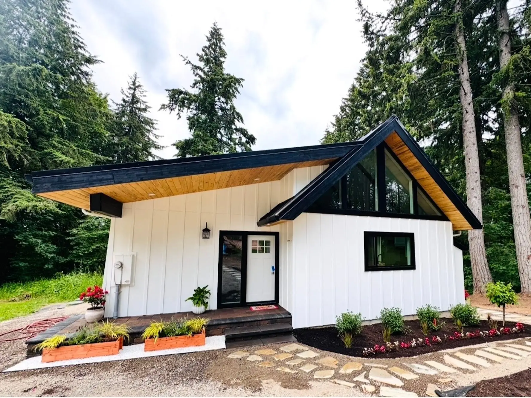 A small white house surrounded by trees.