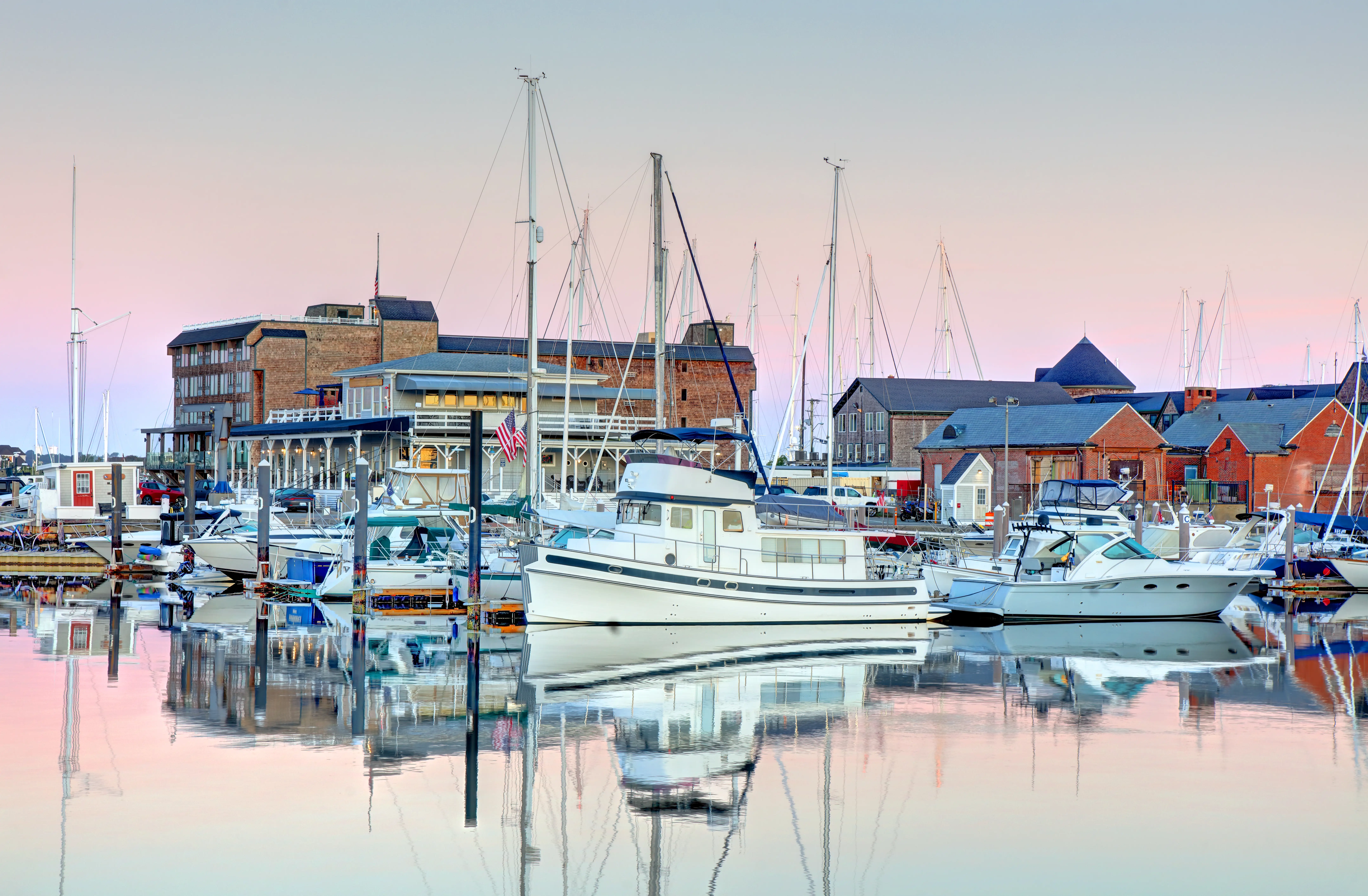 Boats on water in Newport under blue, pink sky