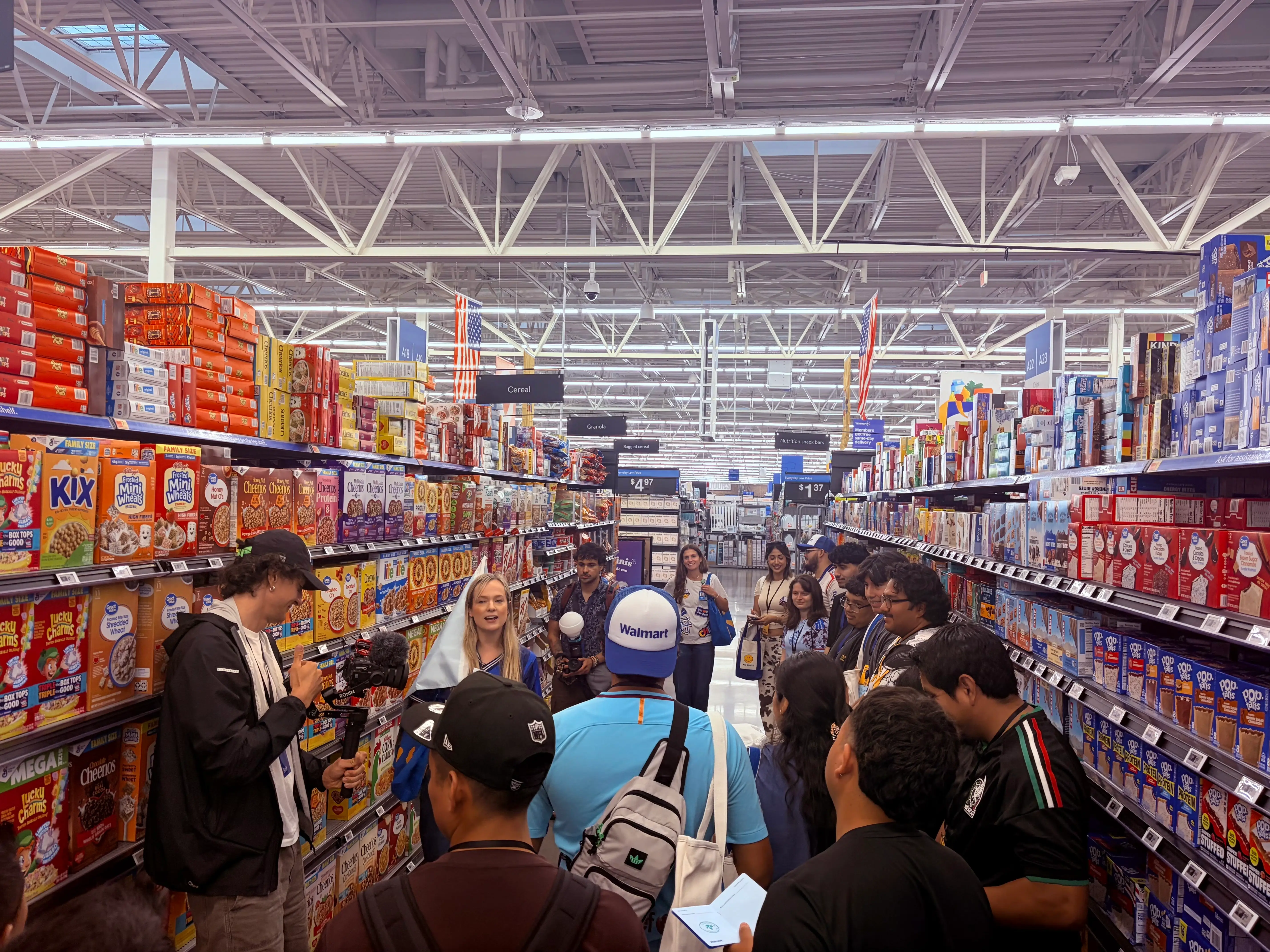 A spokesperson walks visitors through the cereal aisle of a Walmart store.