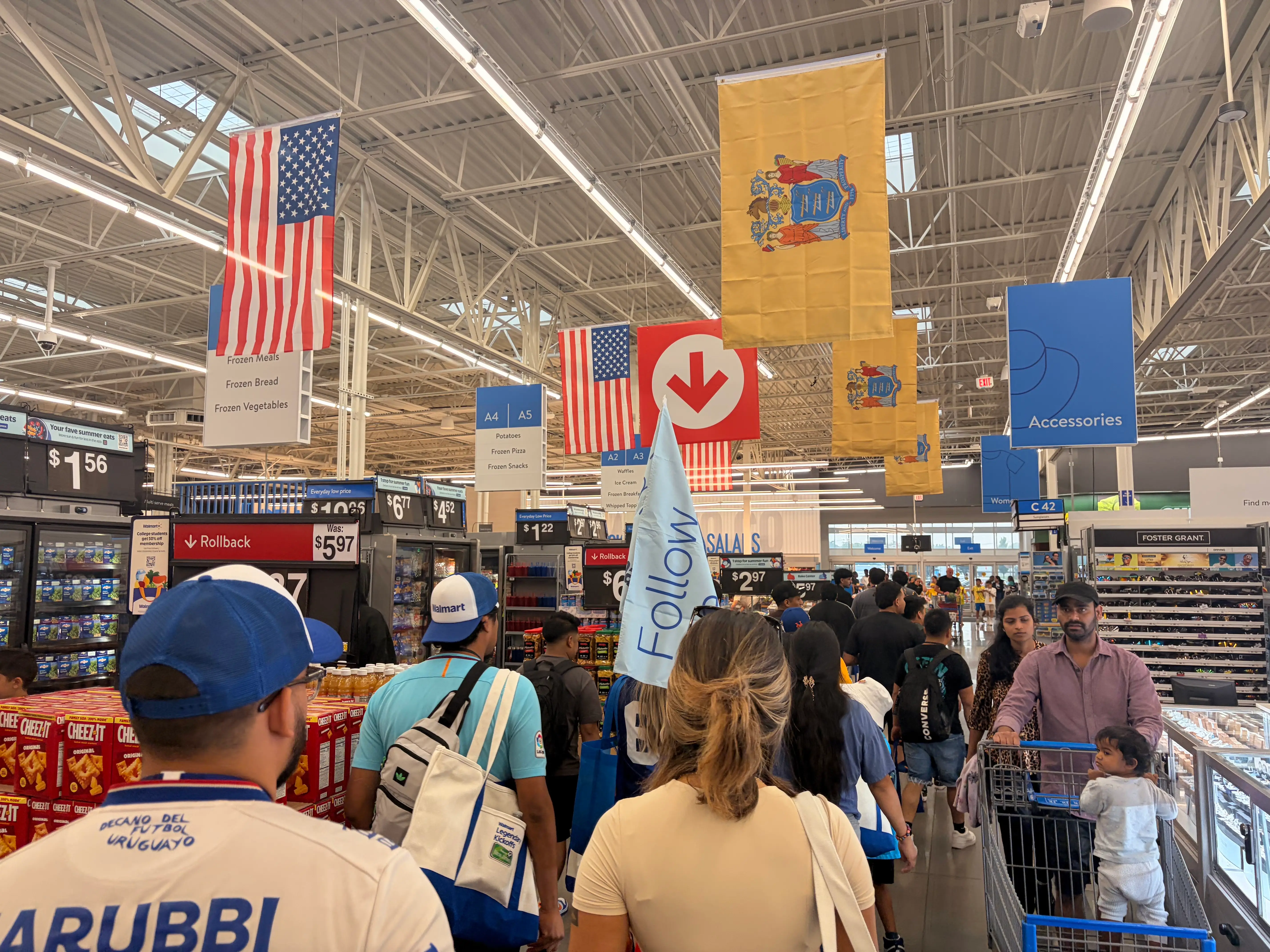 A Walmart employee leads tour guests through a Walmart with a light blue