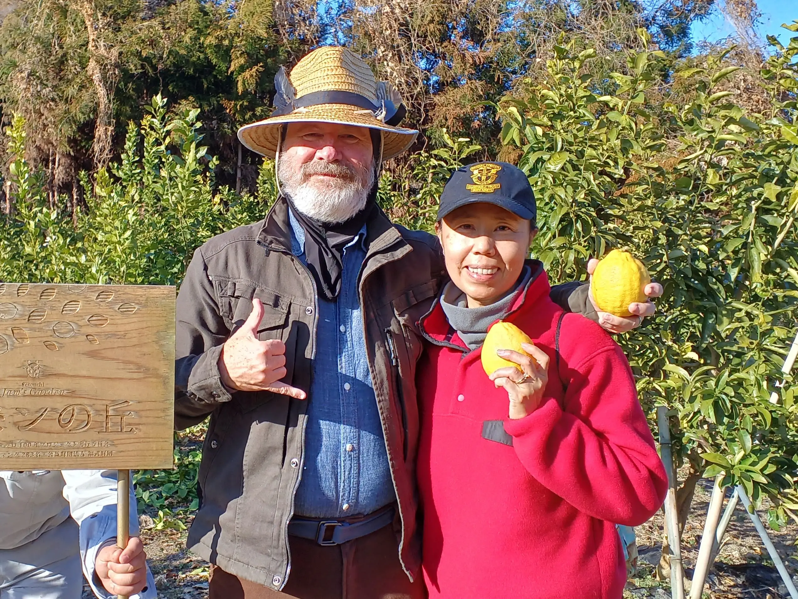 A couple posing with citrus fruits they harvested.