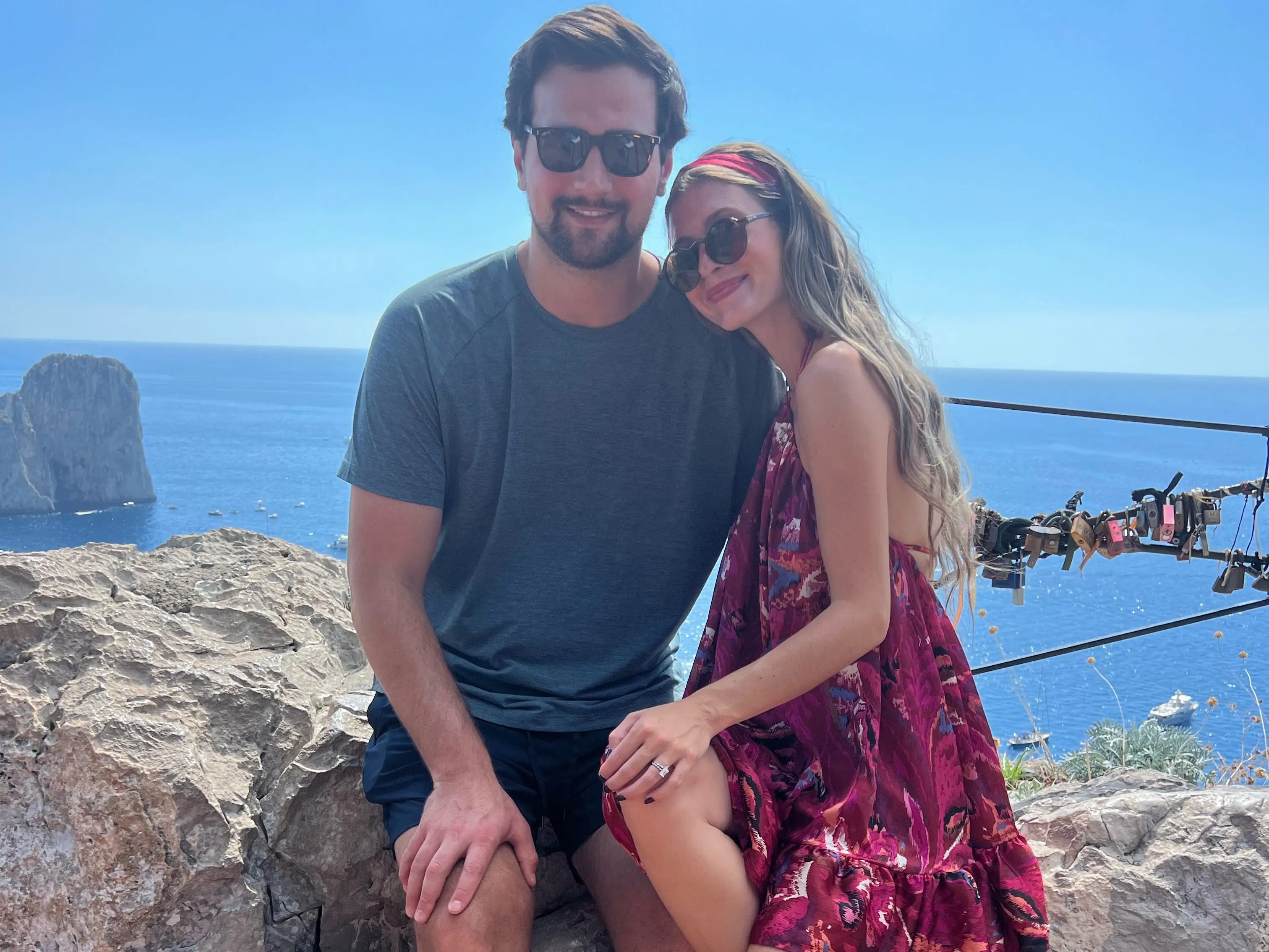 Author and her husband sitting on rock, smiling in Capri