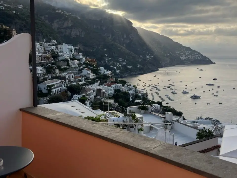 View of water, buildings, cliffs from hotel balcony