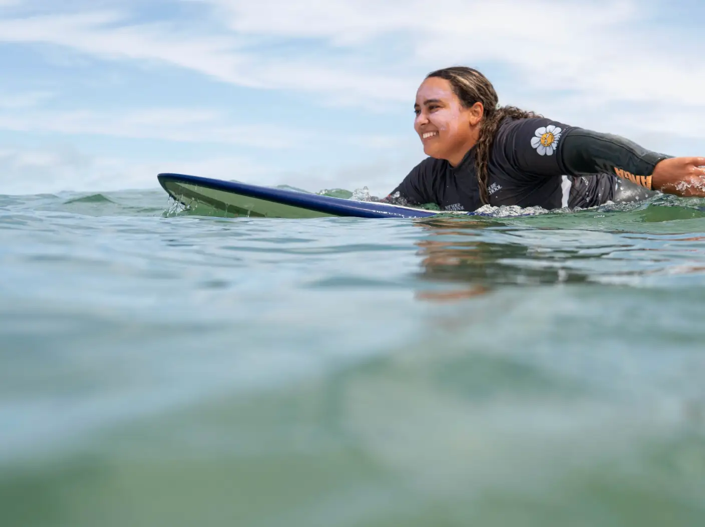 The writer surfing in Portugal, with sunscreen with on her face.