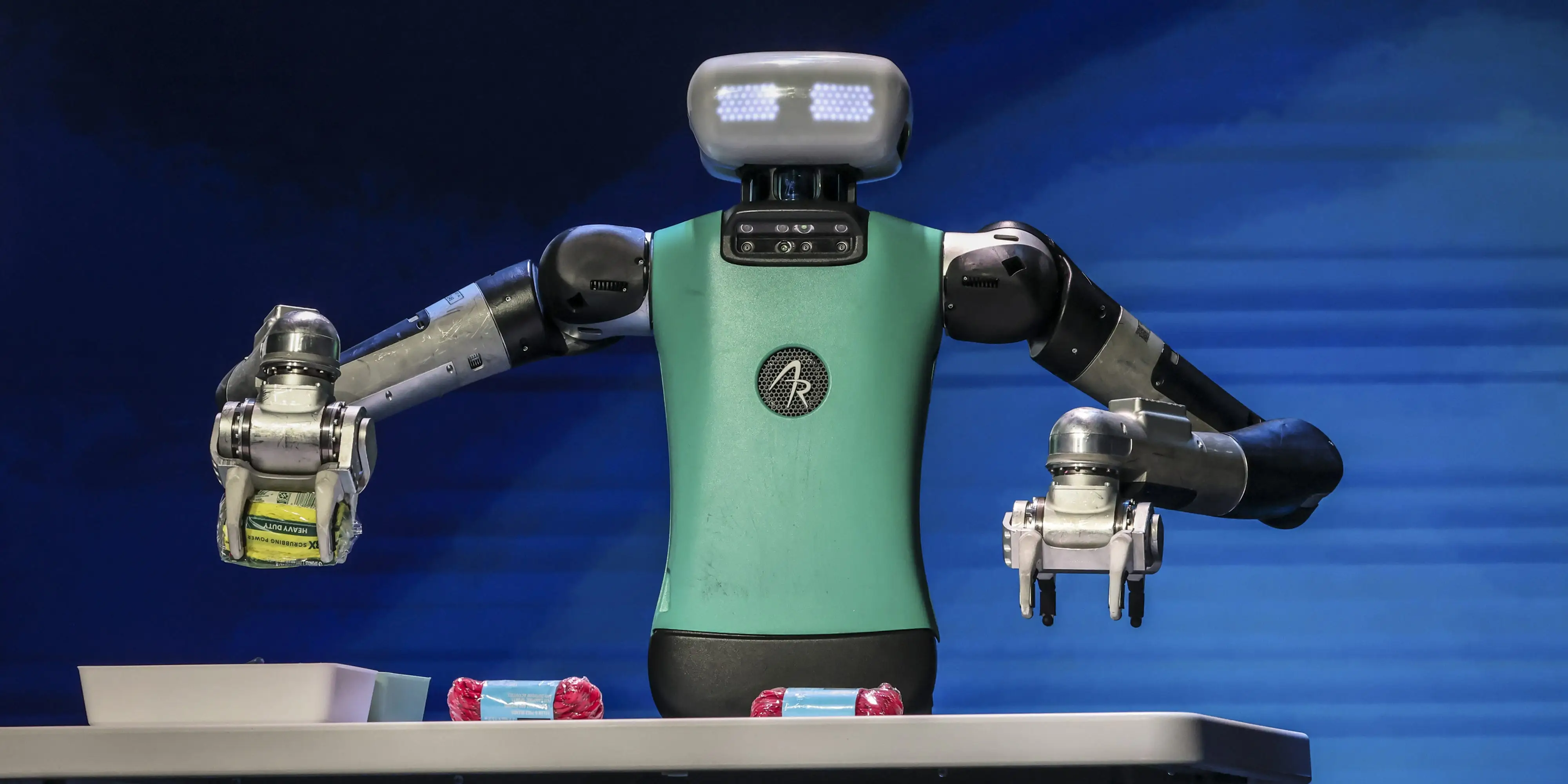 A humanoid robot picks up an item.